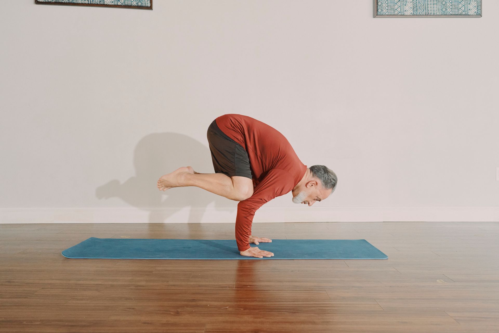 Four dancers in mid-air splits, outdoors near industrial structures.