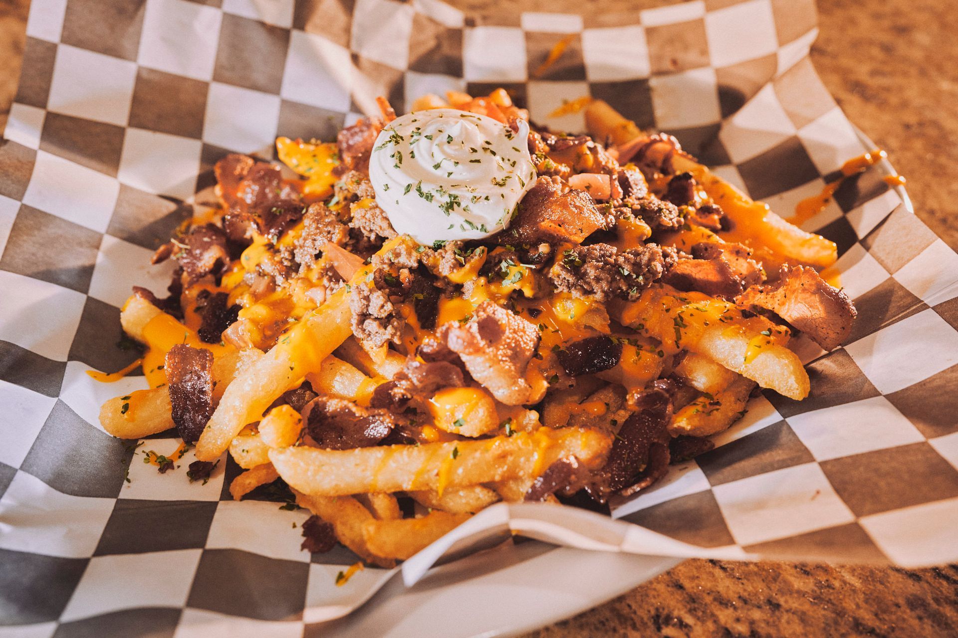 A close up of a plate of food on a checkered paper on a table.