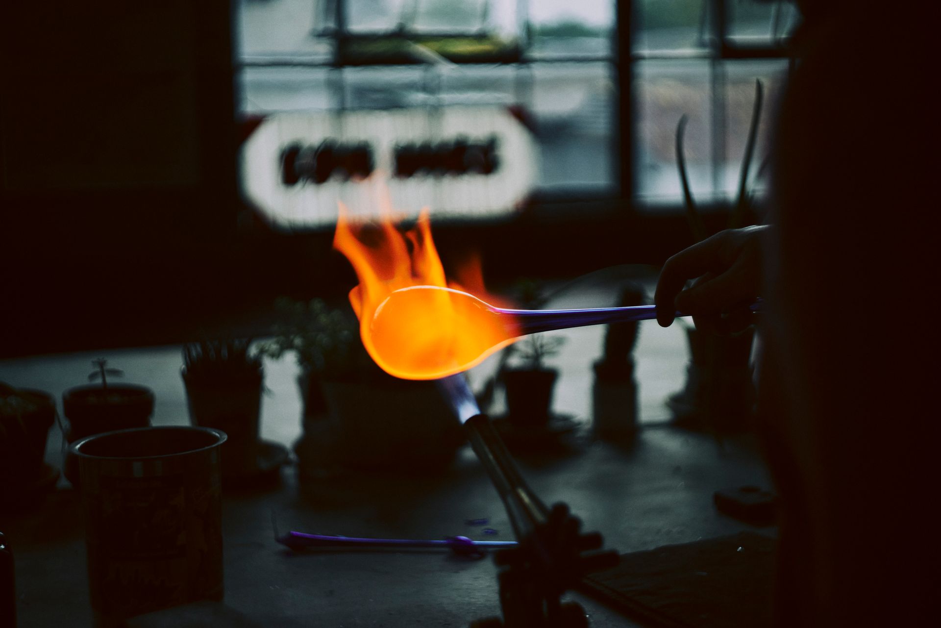 A skincare product on a tray with a flower, towels, and a bathtub in a warm-toned bathroom.