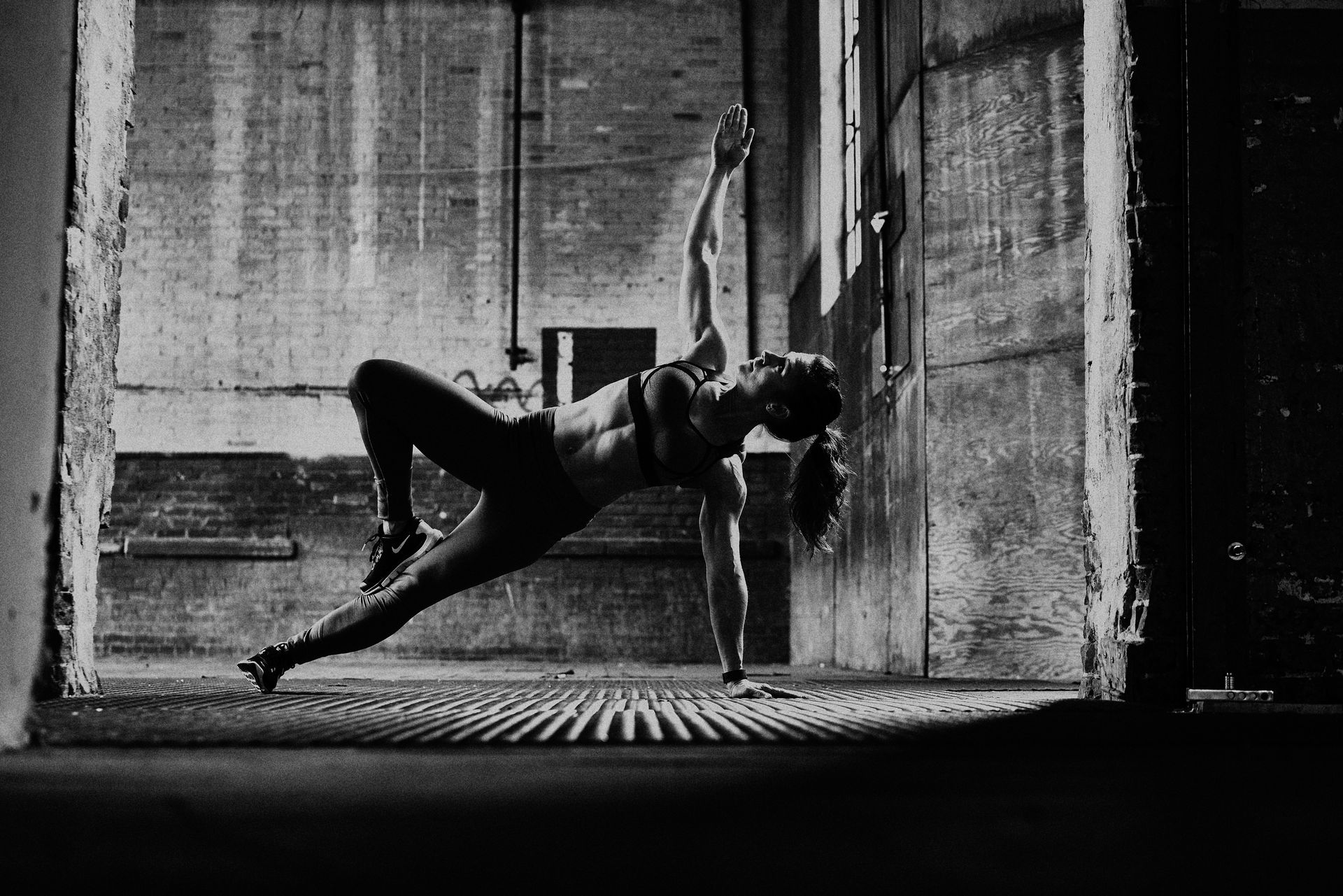 A woman is doing a yoga pose in a black and white photo.
