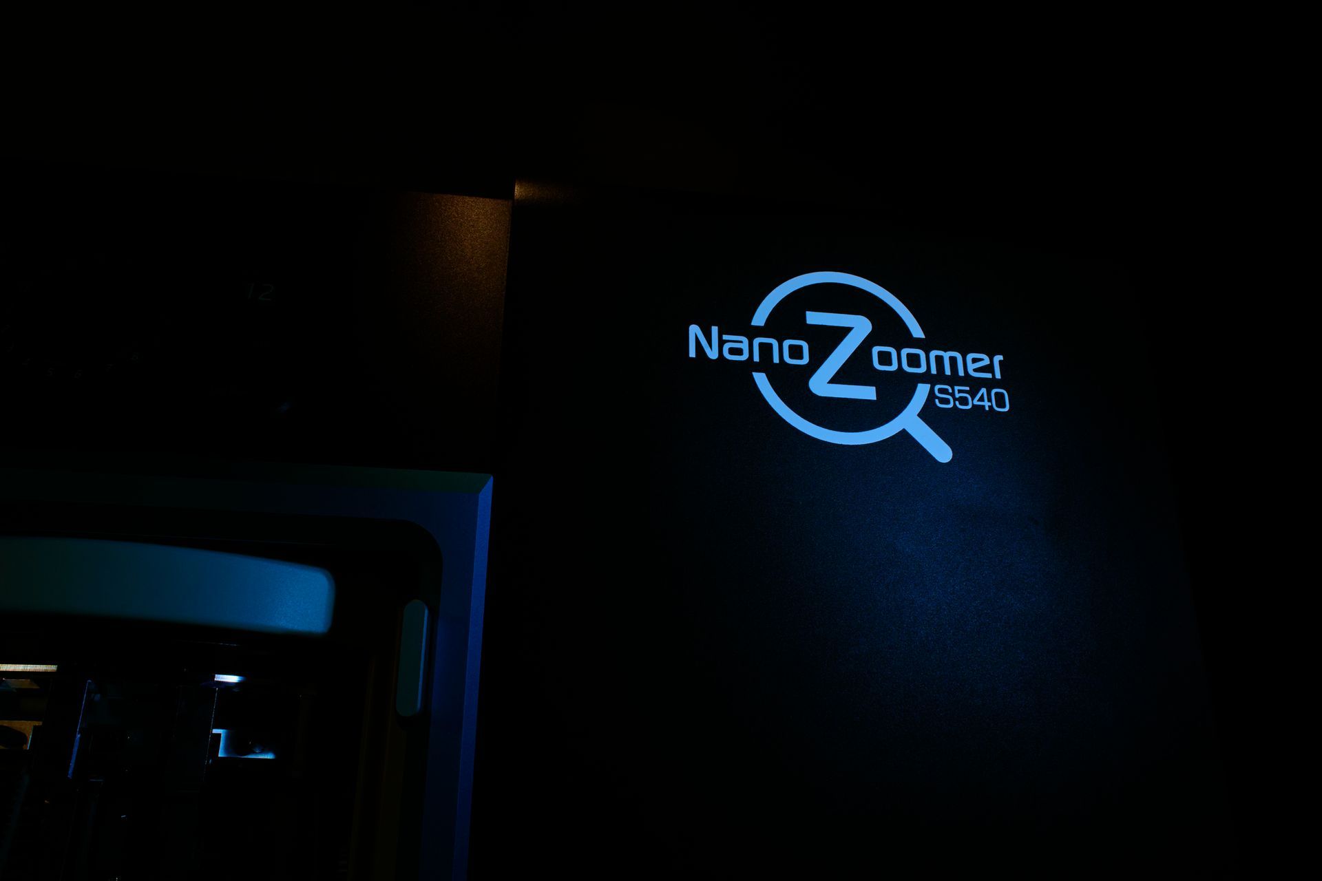 Laser marking machine with blue and white casing on a metal stand.