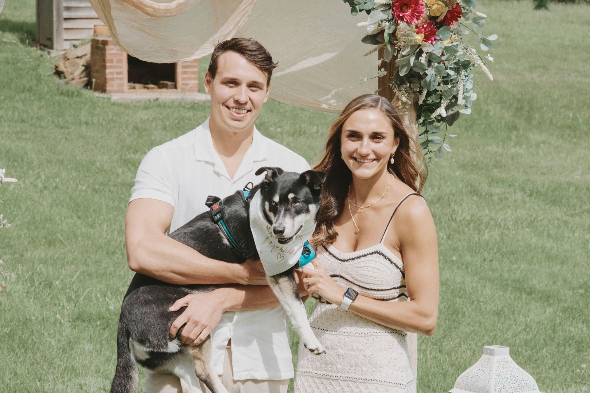 A man and a woman are posing for a picture with their dog.