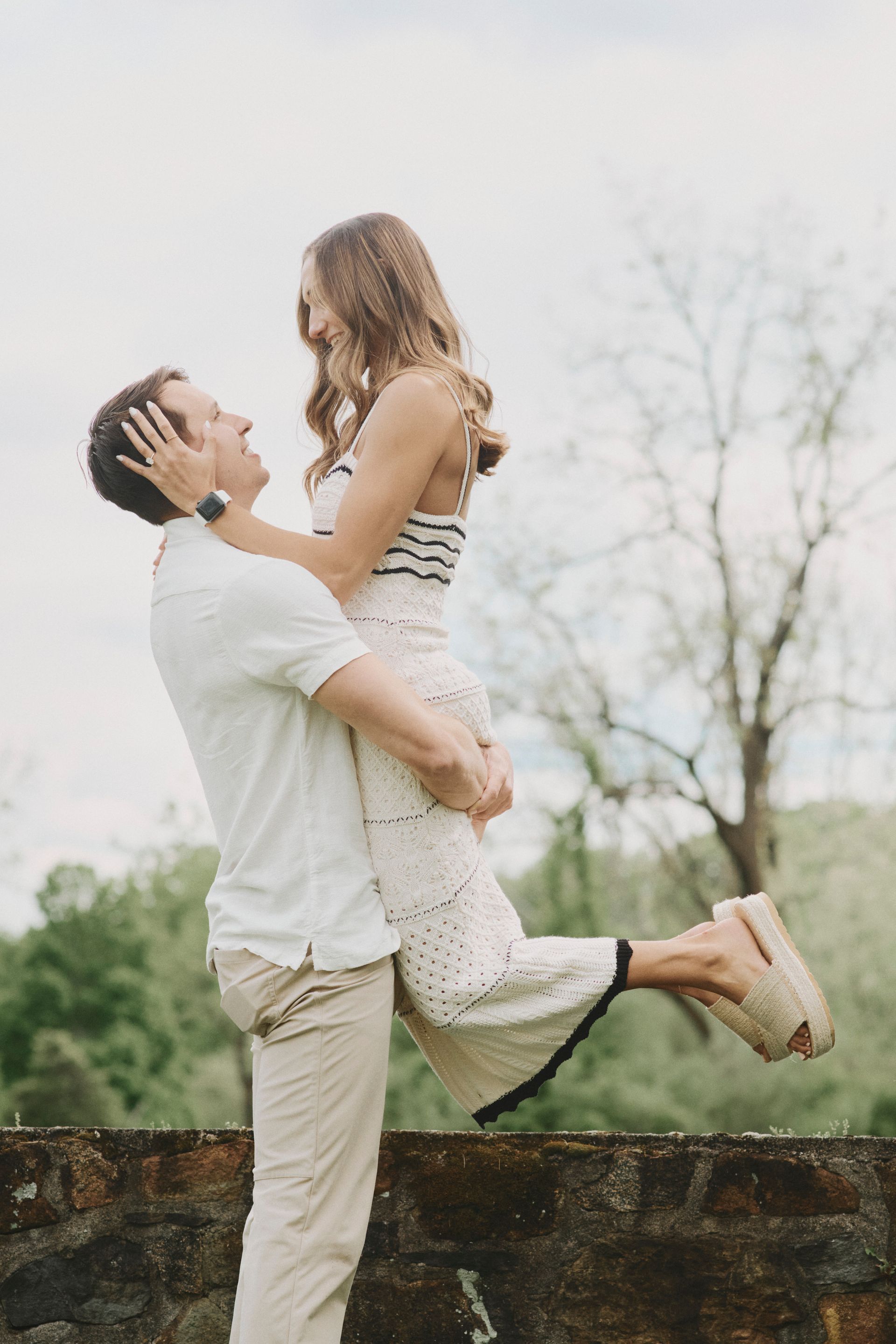 A man is holding a woman in his arms and they are looking at each other.