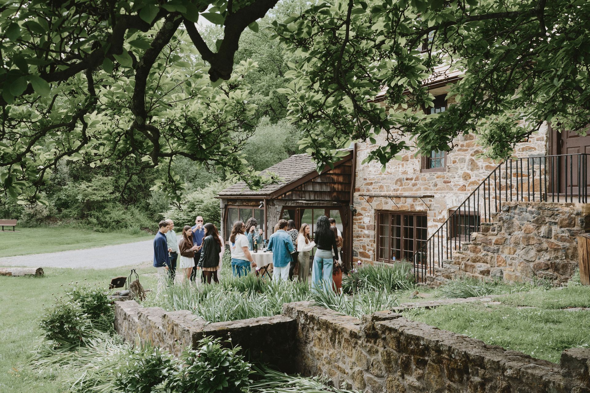 A group of people are standing in front of a stone building.