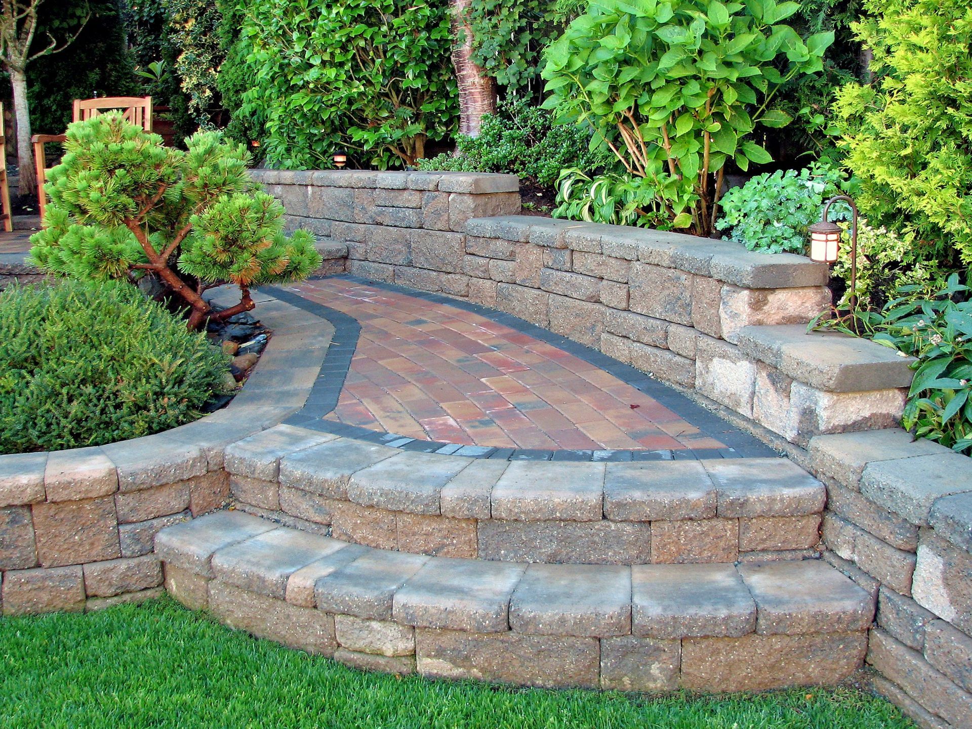 A stone wall with steps leading up to it in a garden