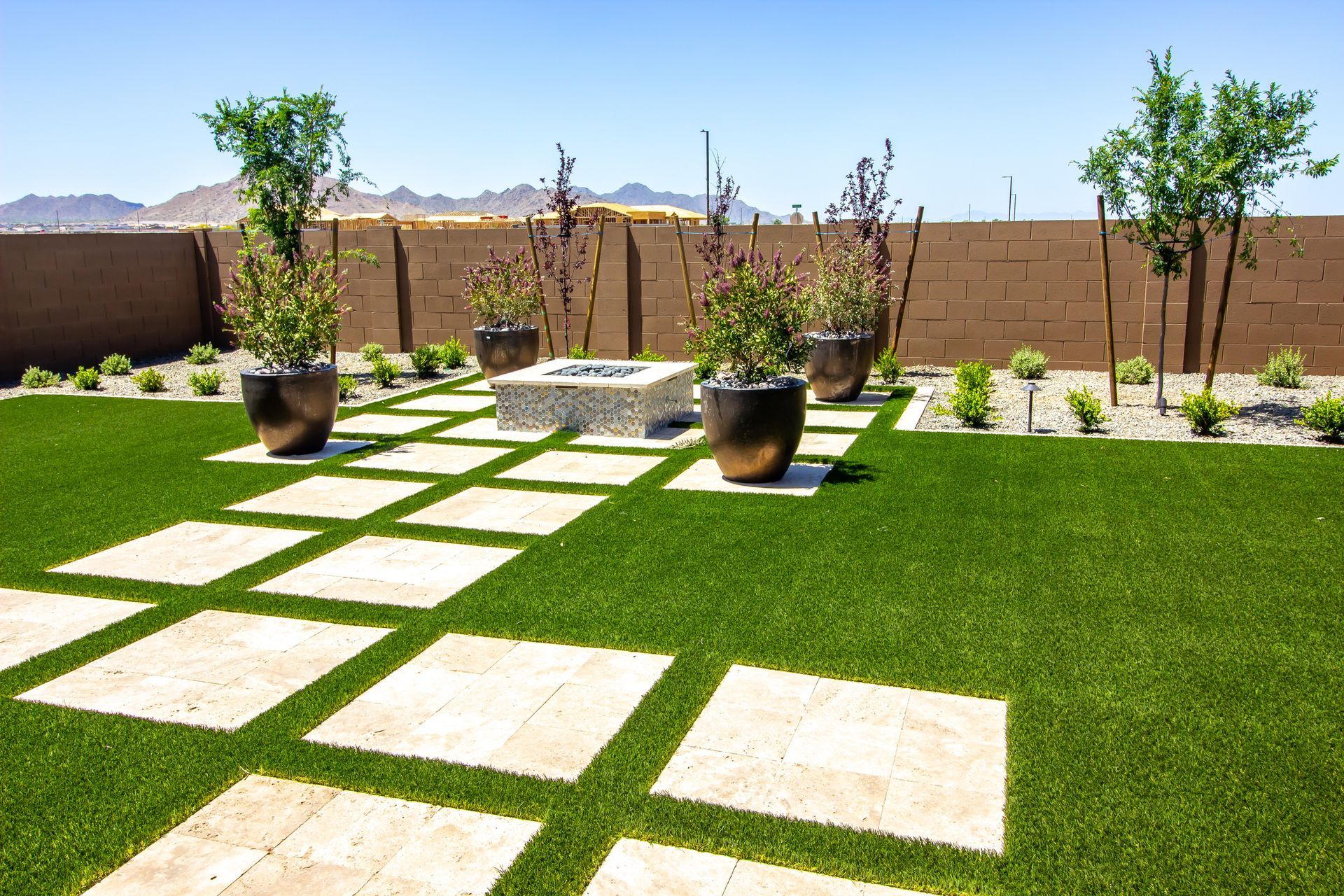 A lawn with a fire pit and potted plants