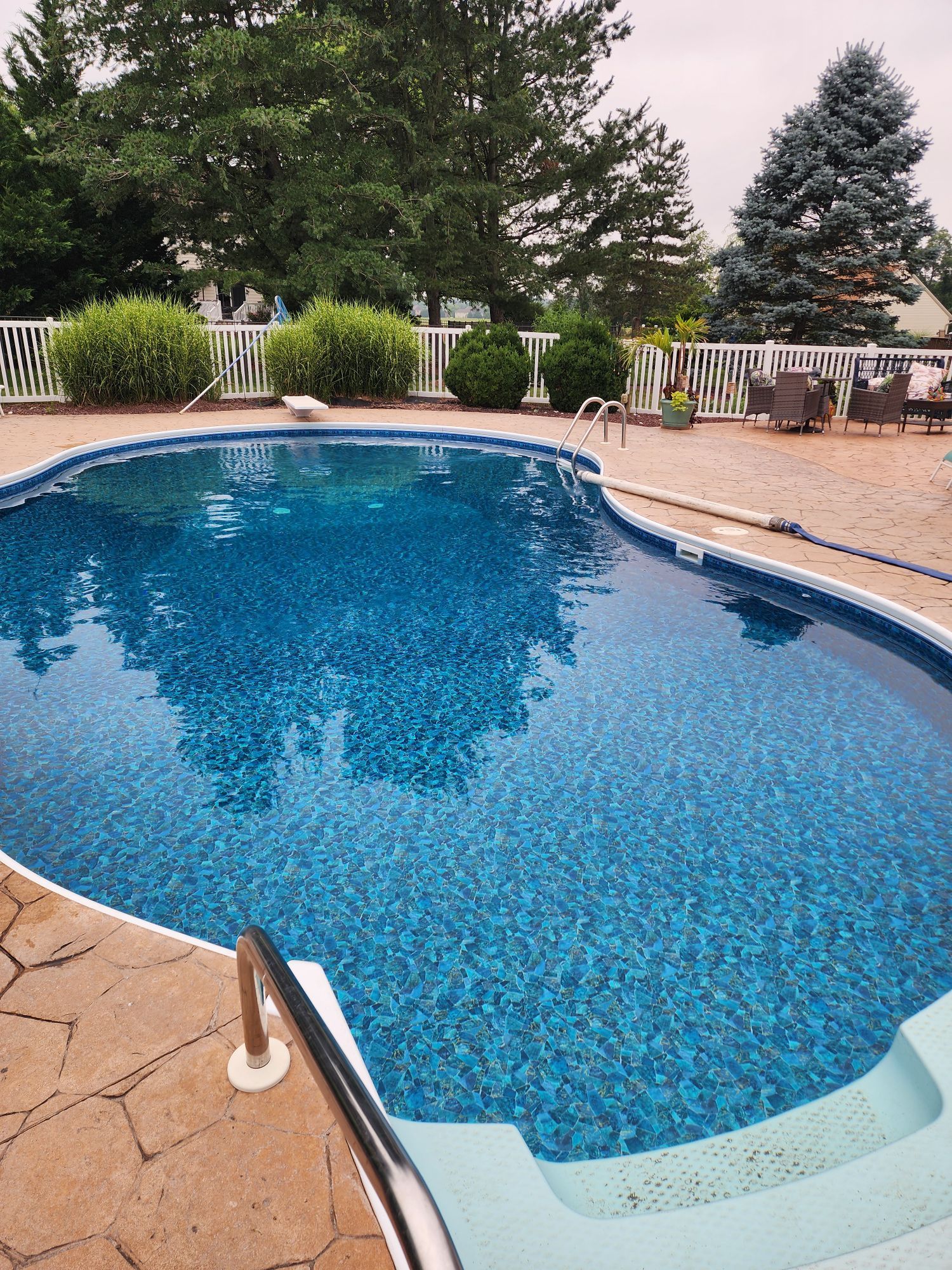 Water tanker truck parked in front of a house. The tank has a landscape mural.