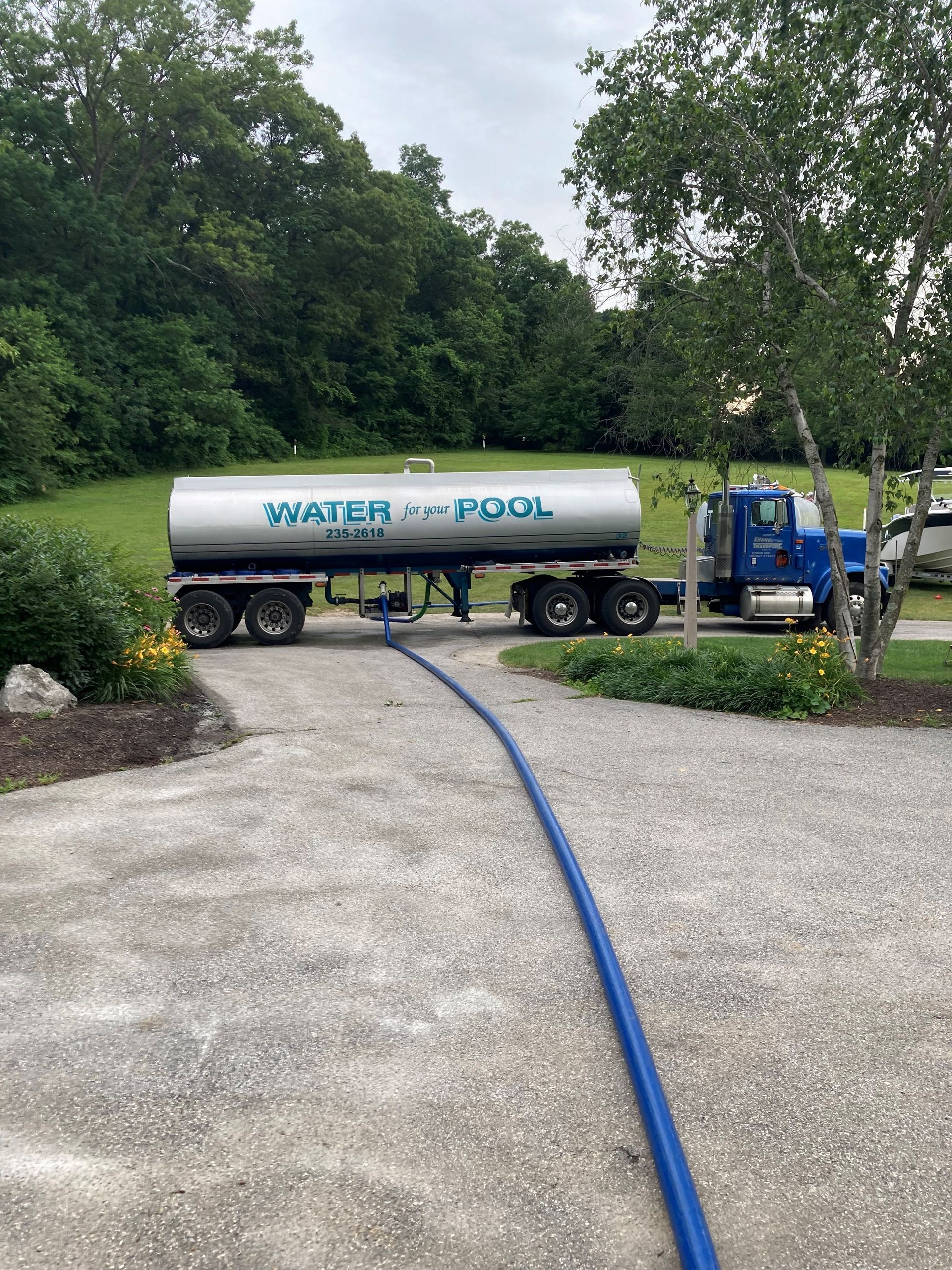 White tanker truck on a road, pulling a trailer. Overcast sky. White tanker truck on a road, pulling a trailer. Overcast sky.