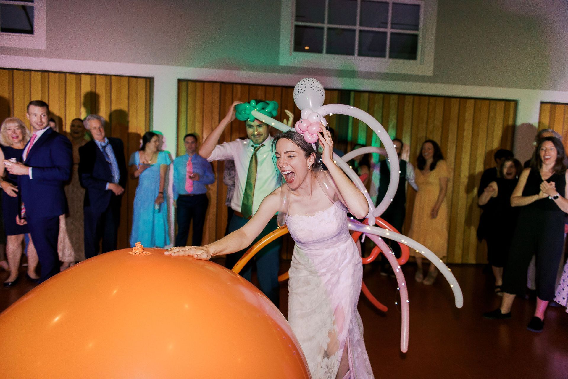 A bride and groom are playing with balloons at a wedding reception.
