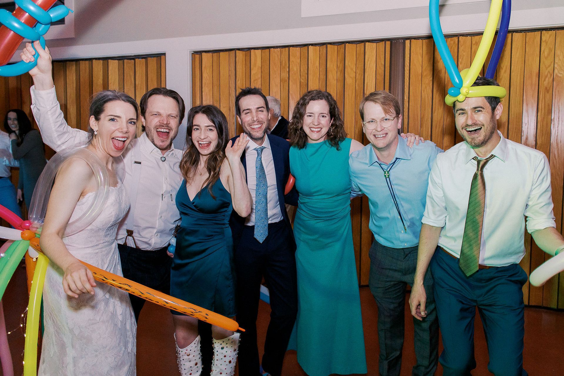 A group of people are posing for a picture with balloons on their heads.
