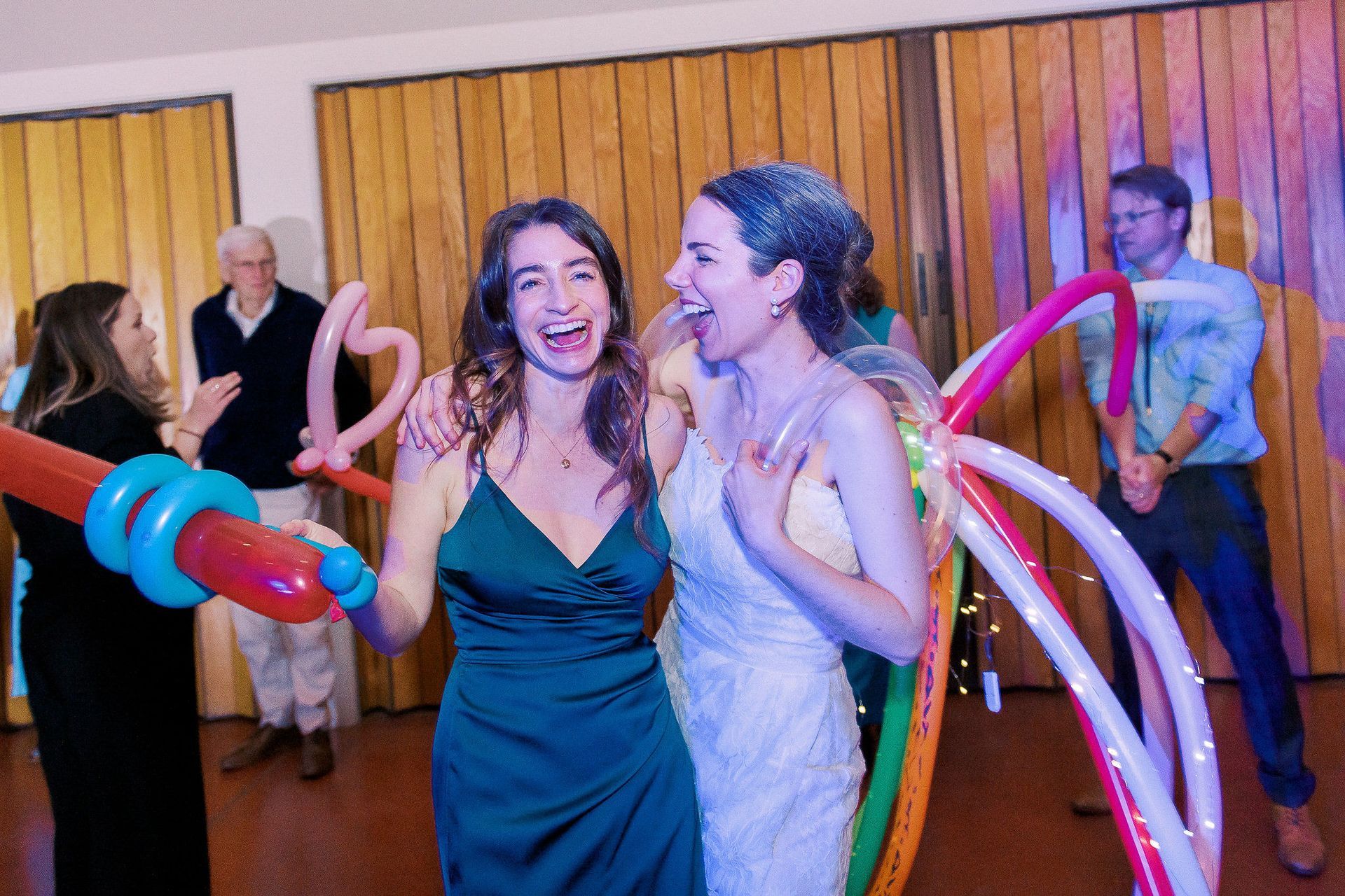 A bride and groom are dancing with balloons at a wedding reception.