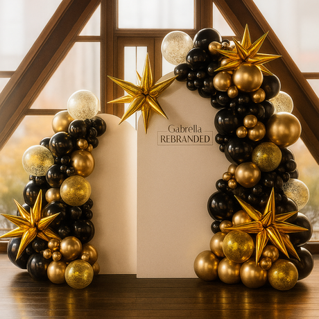 A display of black and gold balloons with gold stars