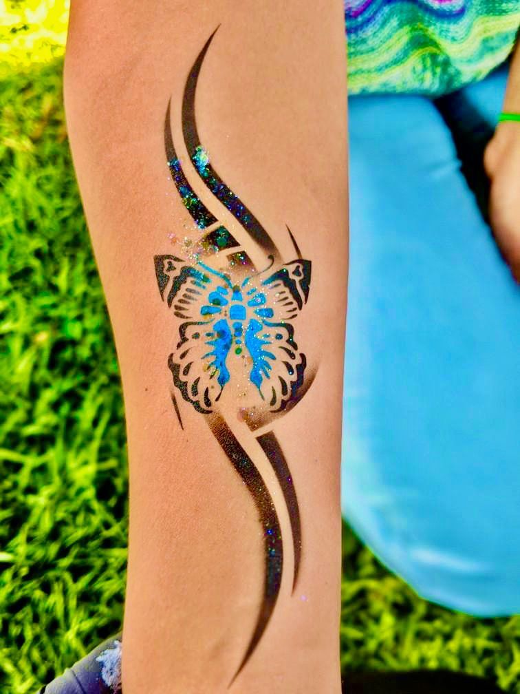 A person has a blue butterfly tattoo on their arm