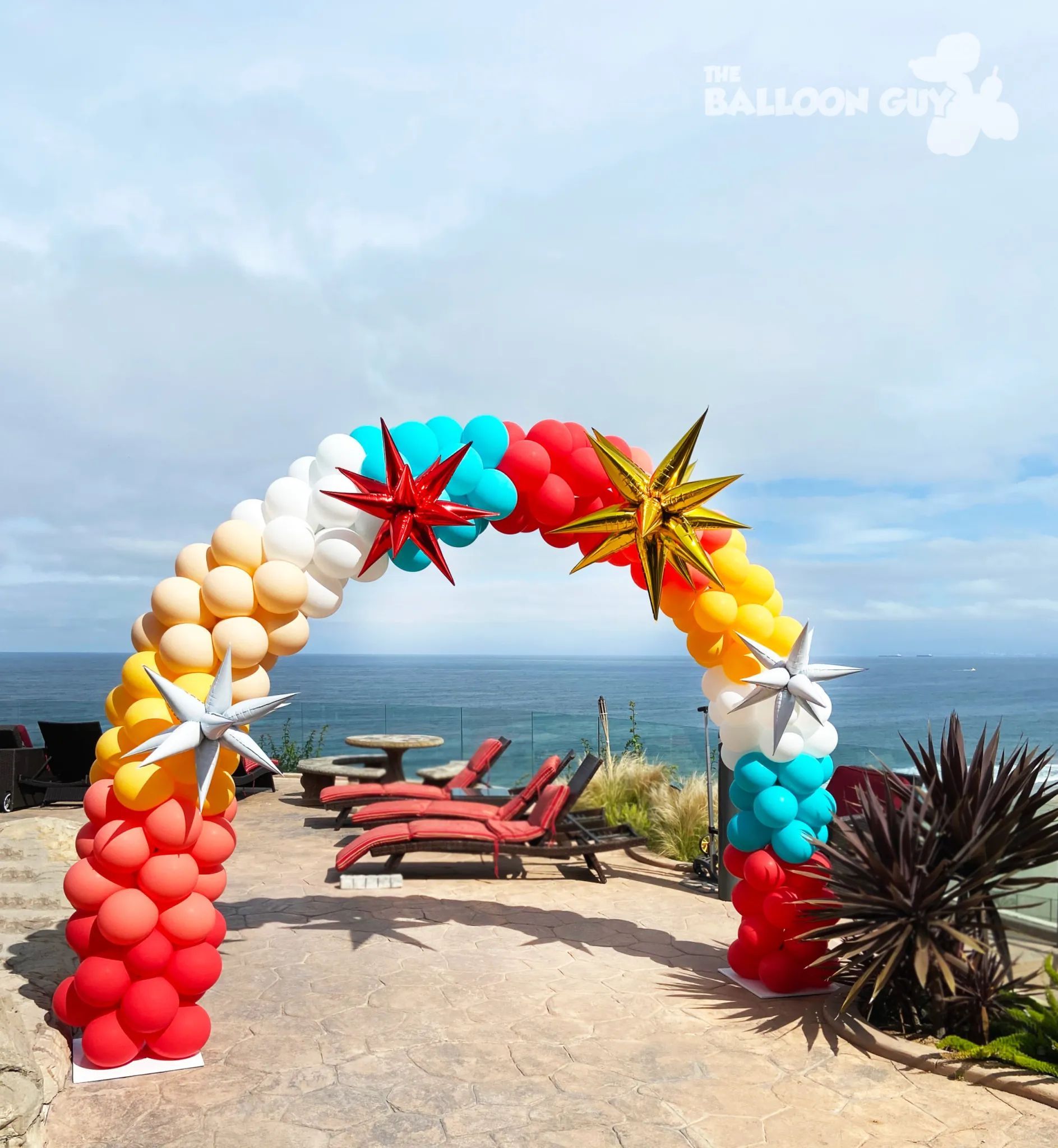 A colorful arch made of balloons with starfish on it