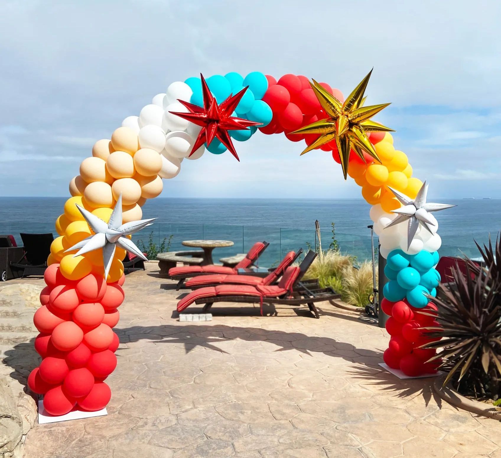 A colorful arch made of balloons with stars on it