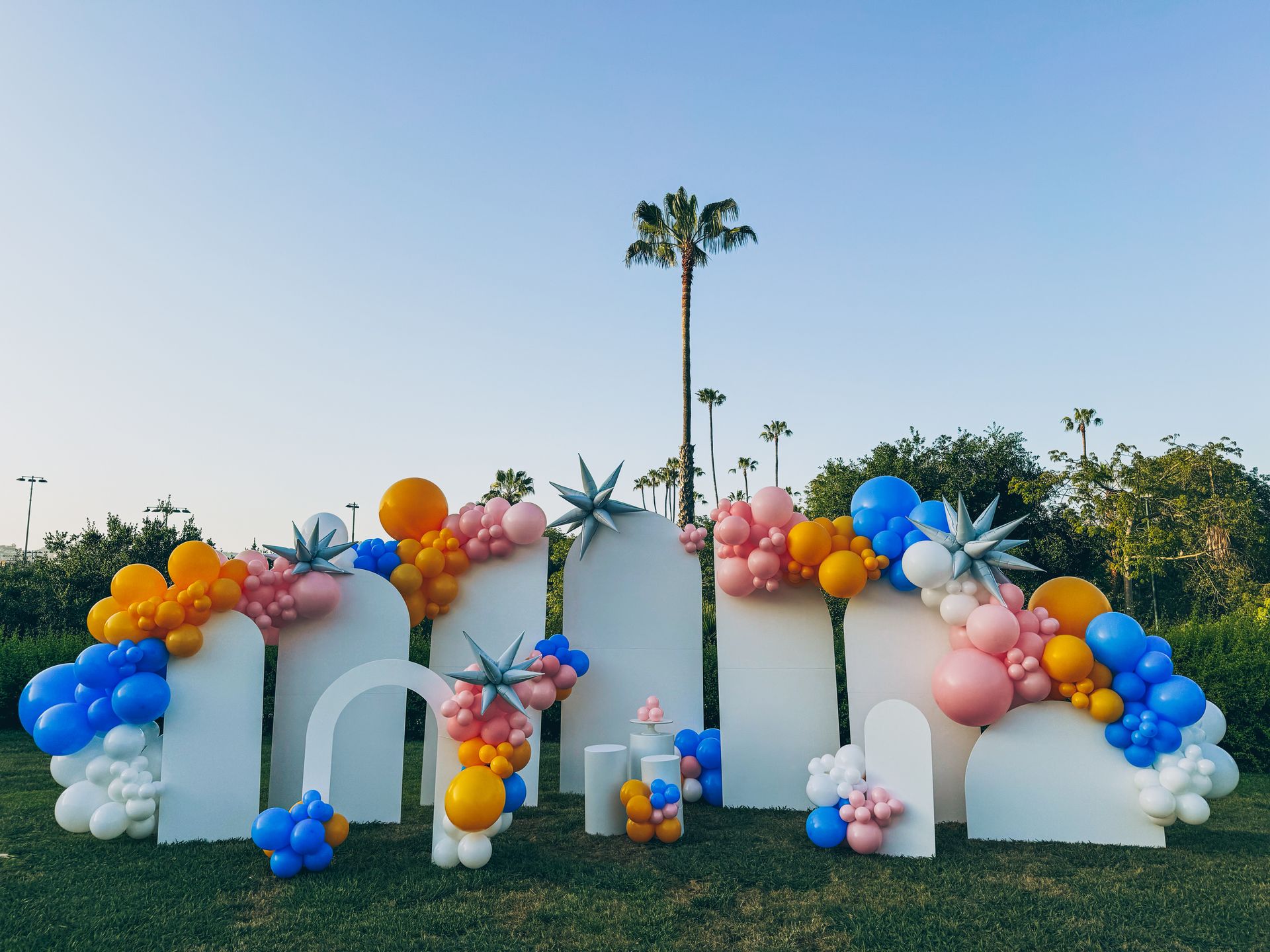 A bunch of balloons are sitting on top of a lush green field.