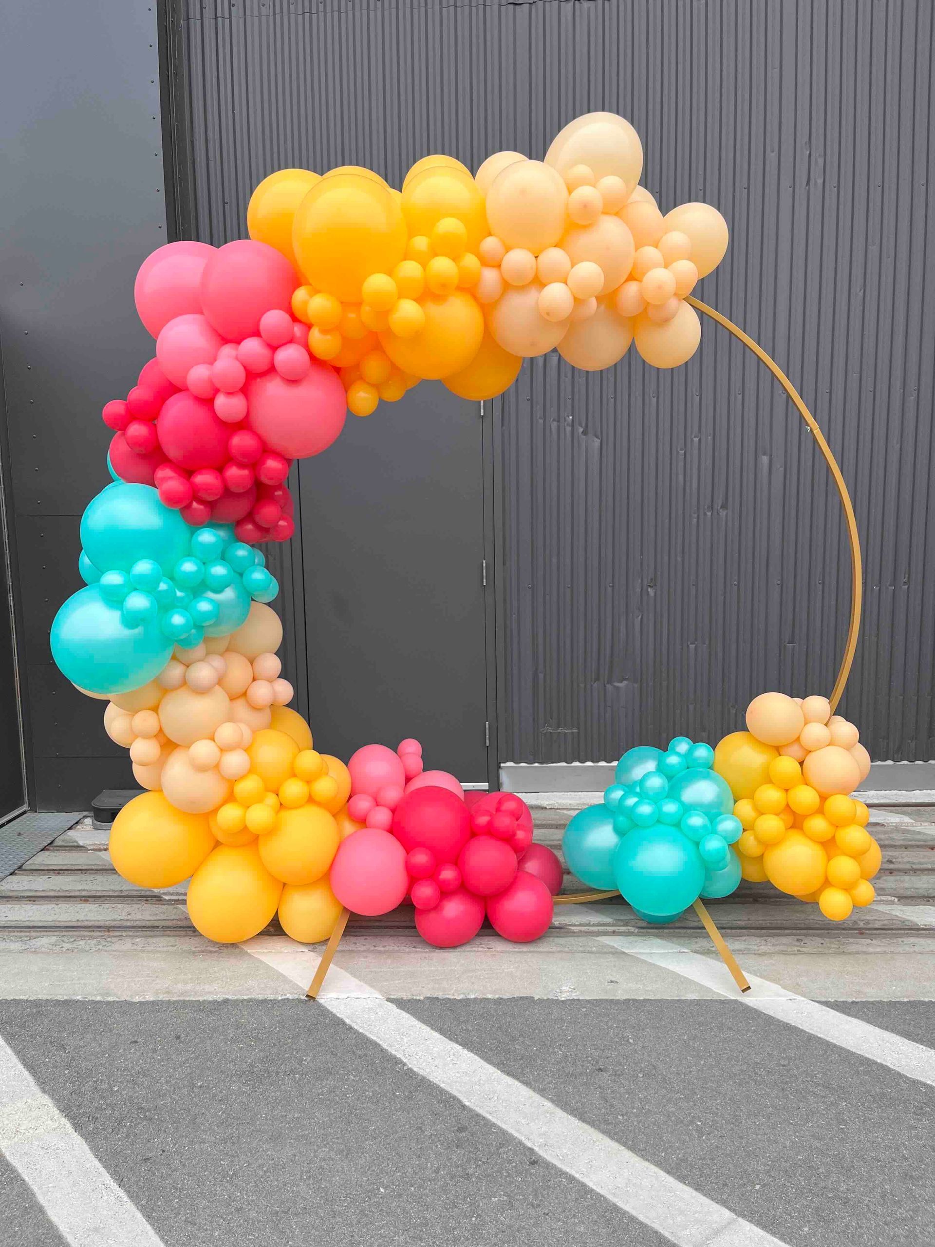 A bunch of balloons are sitting on the ground in a parking lot.