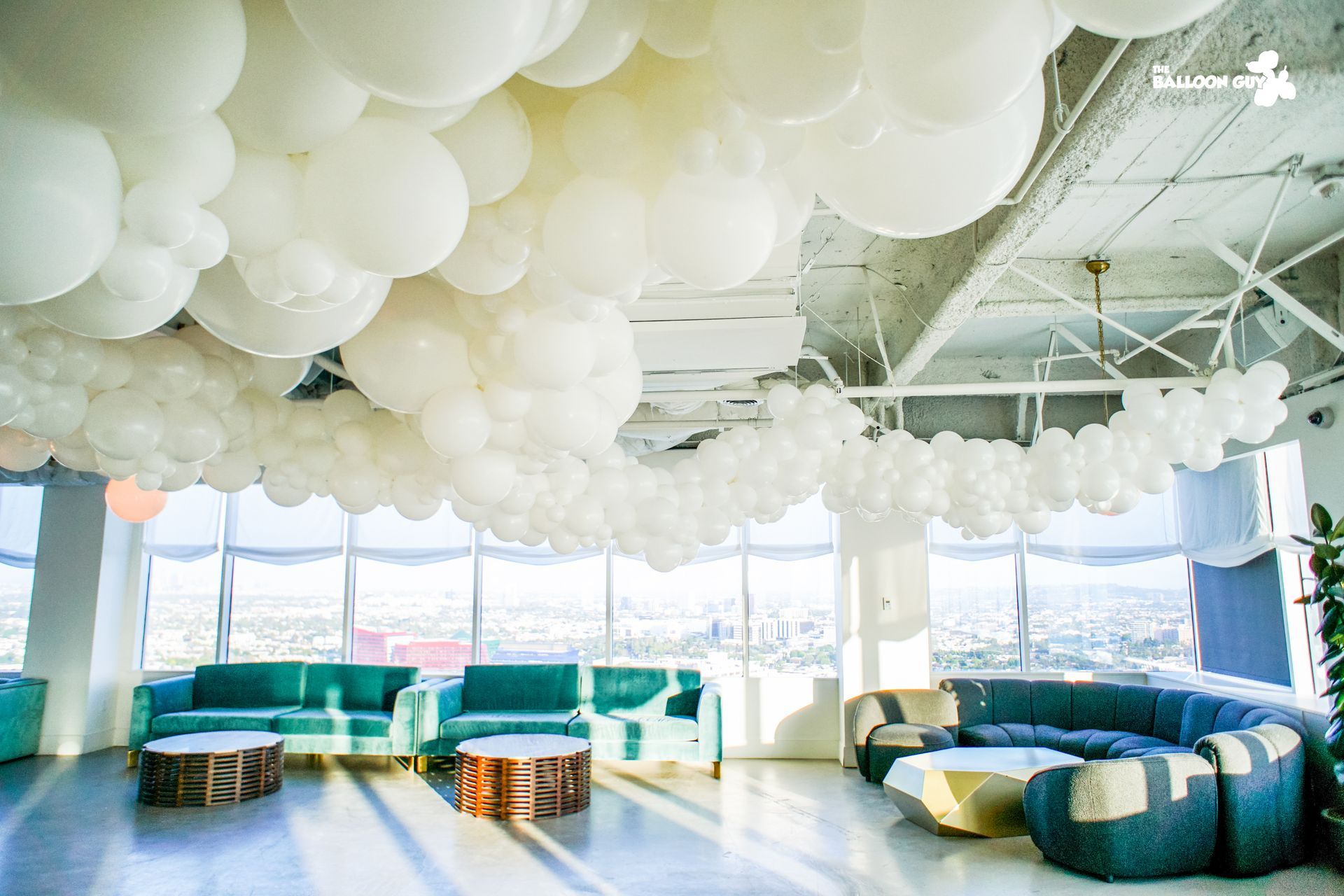 A living room with a lot of white balloons hanging from the ceiling.