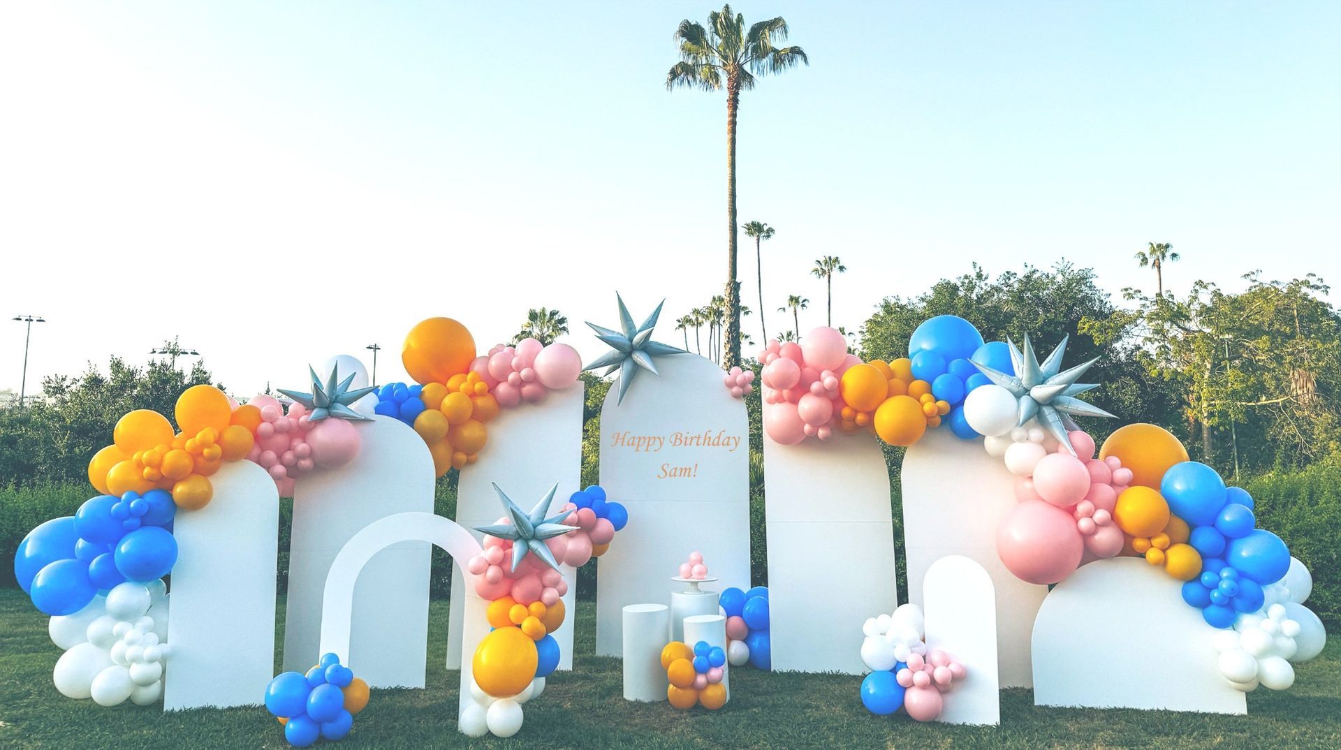 A bunch of balloons are sitting on top of a lush green field.