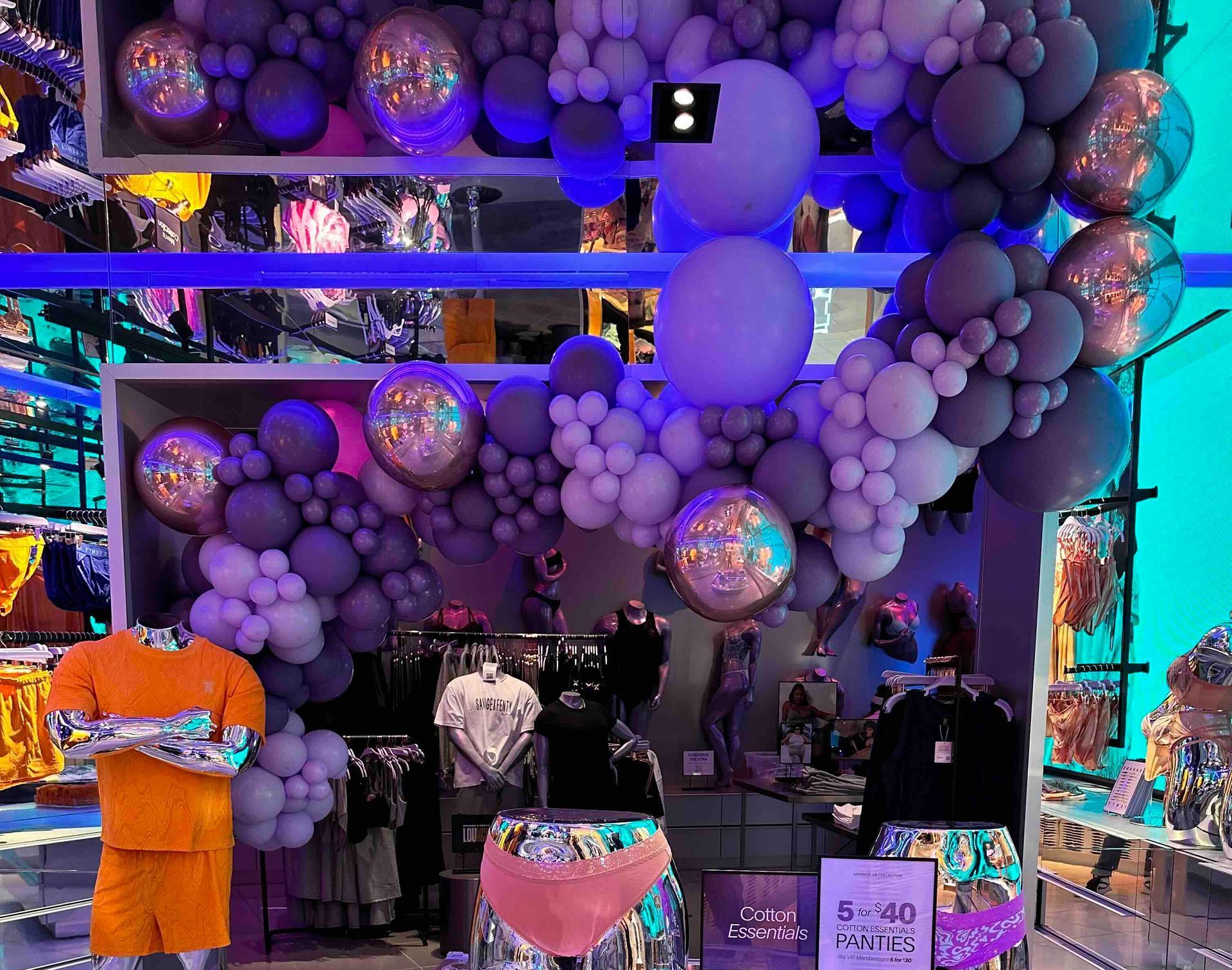 A store with a bunch of balloons hanging from the ceiling