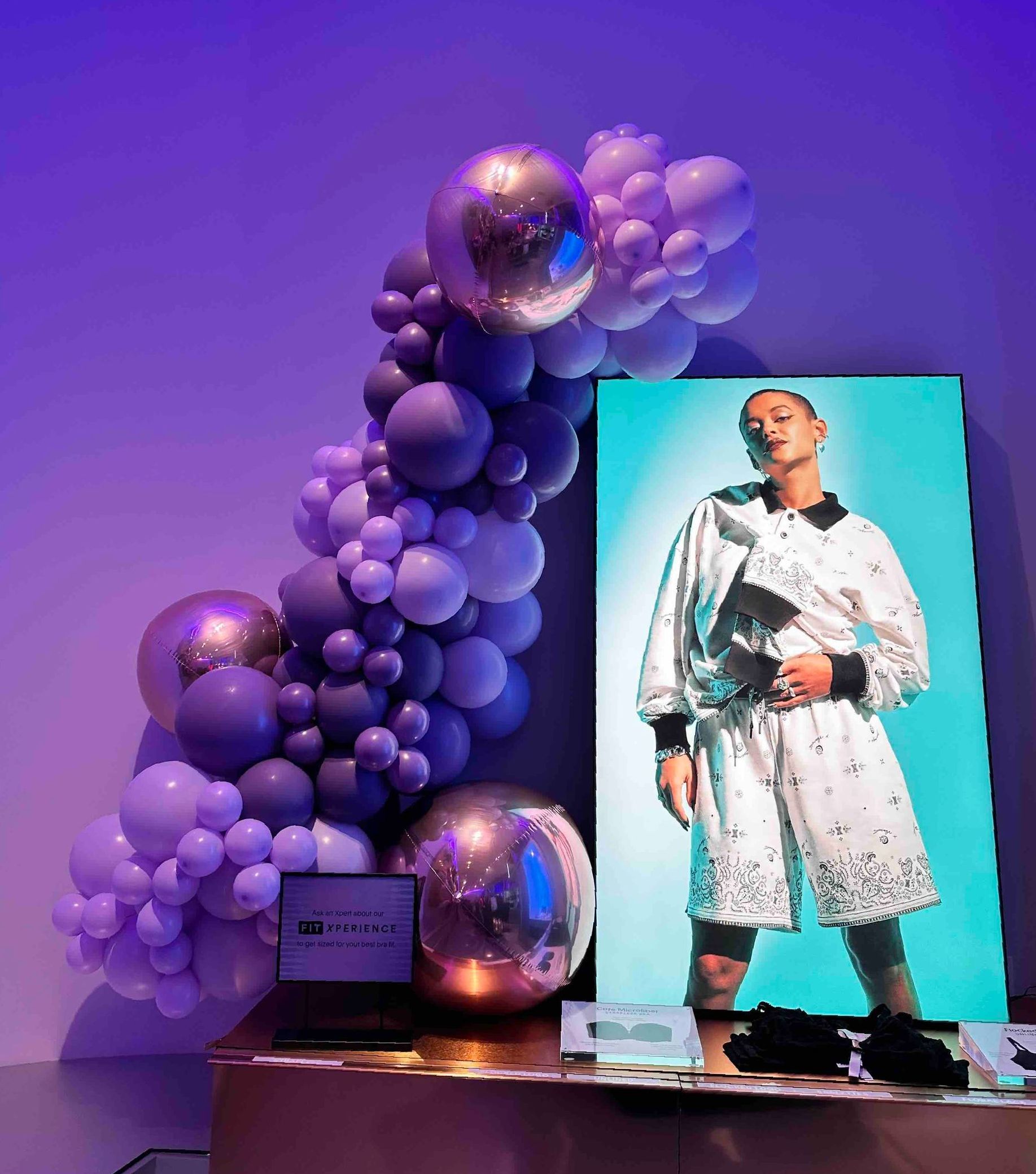 A picture of a man standing next to balloons and a laptop