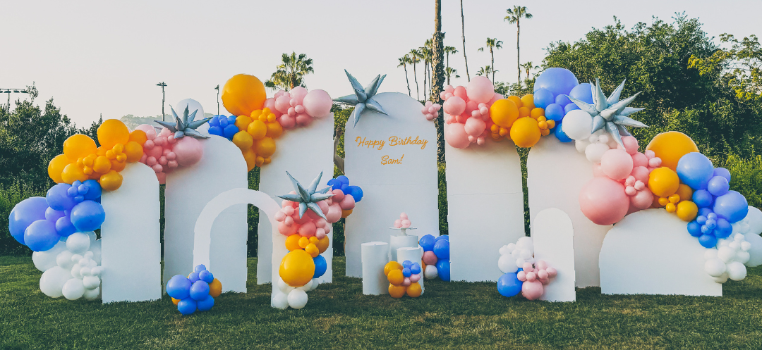 A bunch of balloons are sitting on top of a lush green field.