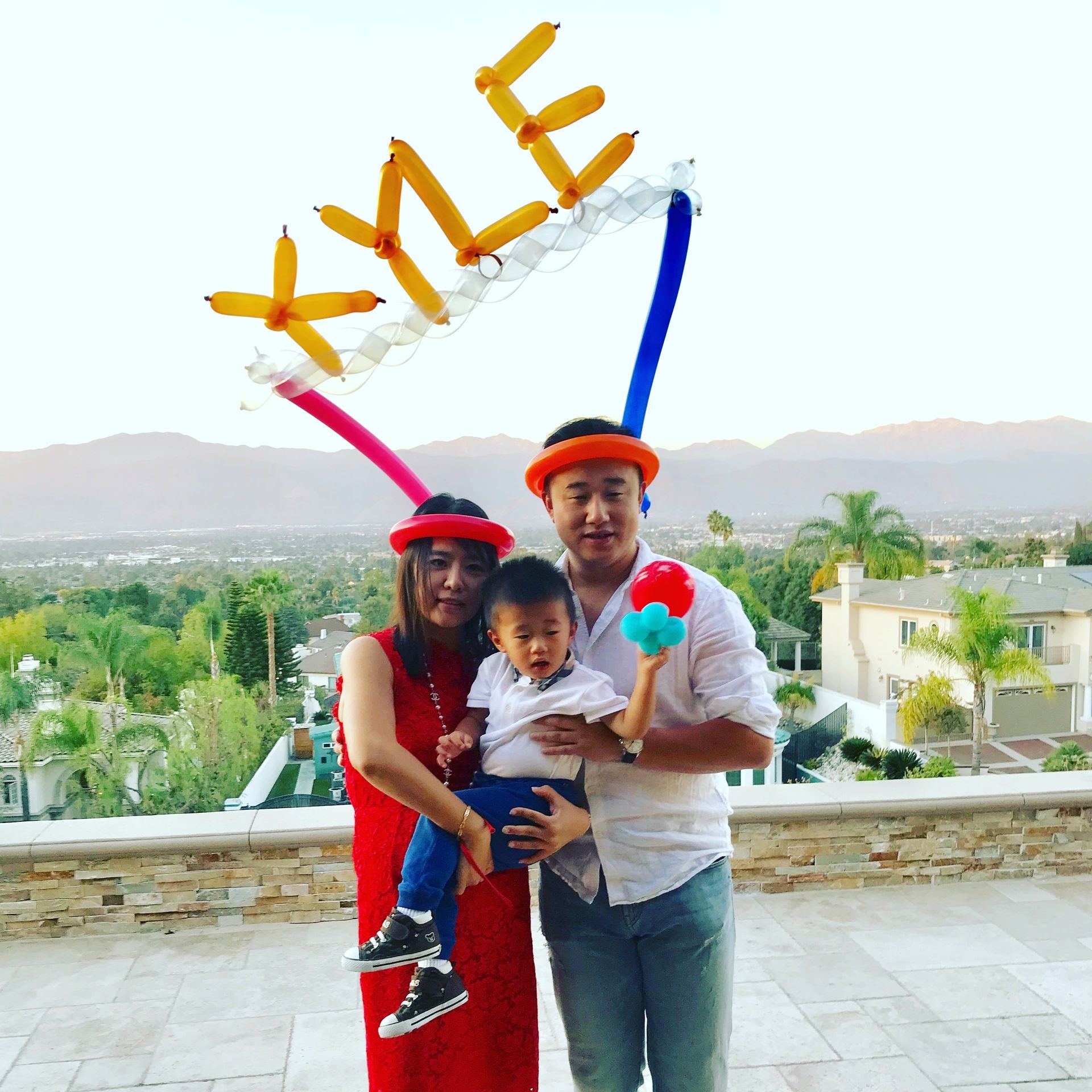 A family posing for a picture with balloons that say kyle