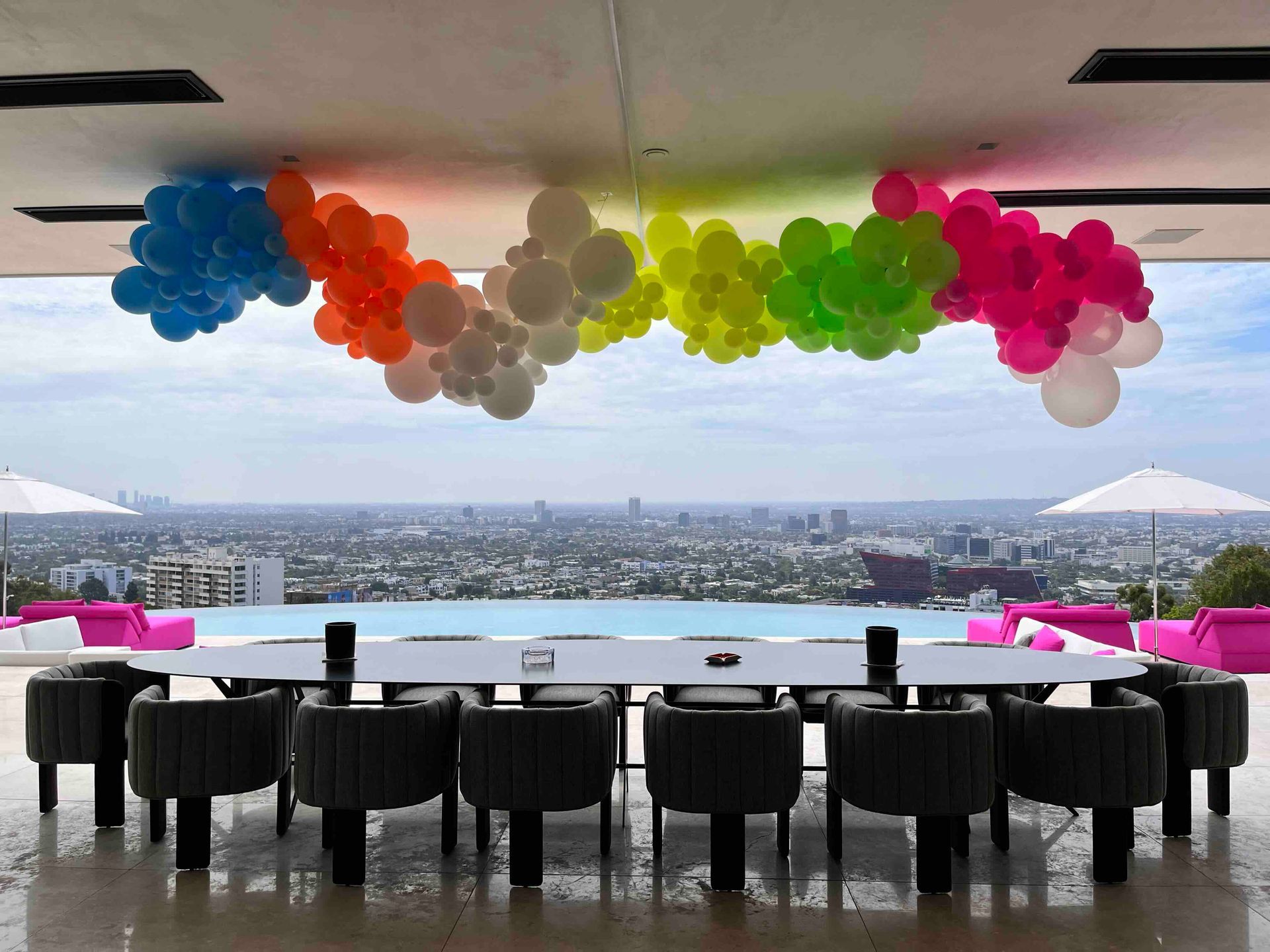 A dining room with a table and chairs and balloons hanging from the ceiling.