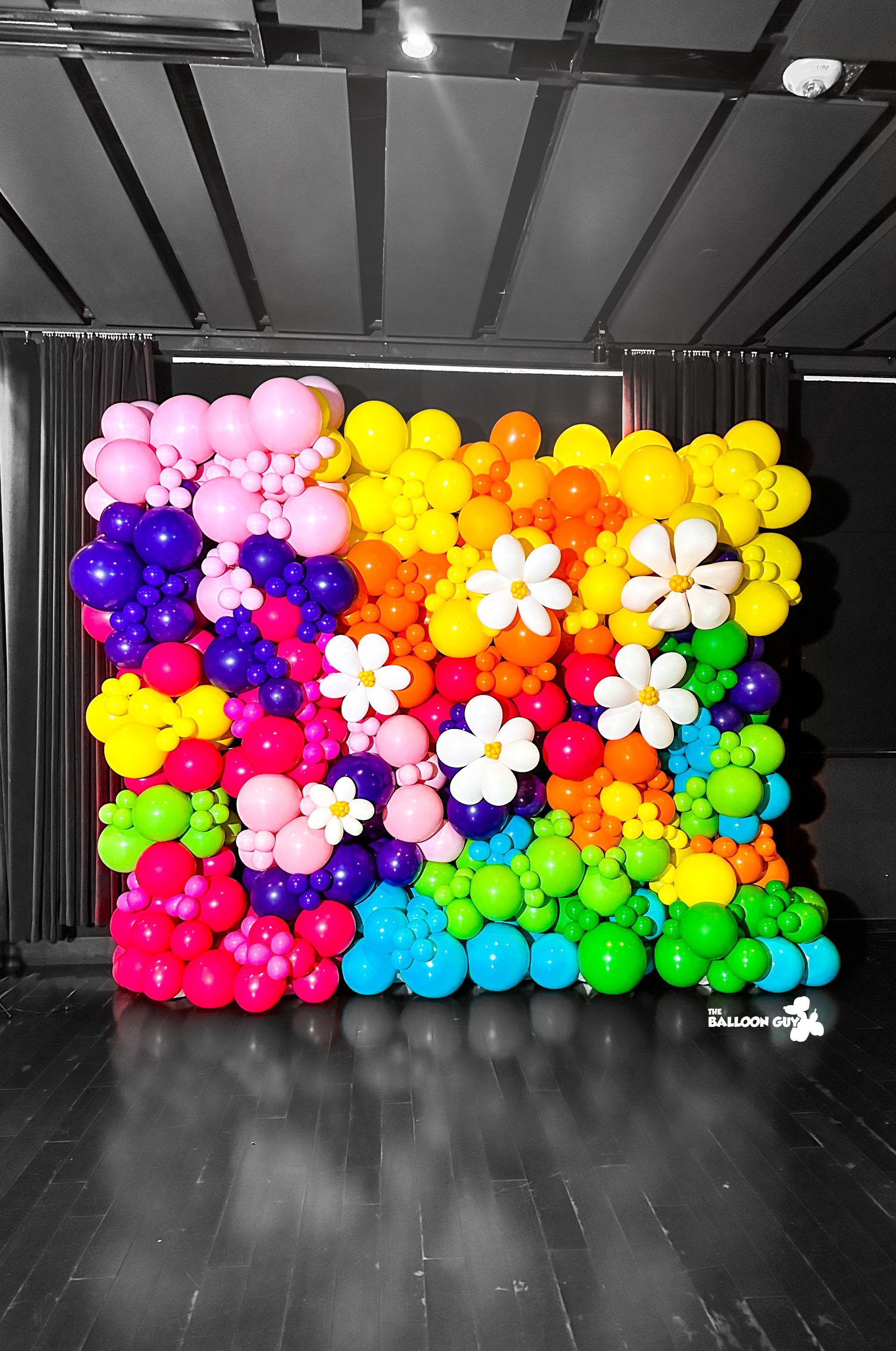 A wall made of colorful balloons and flowers