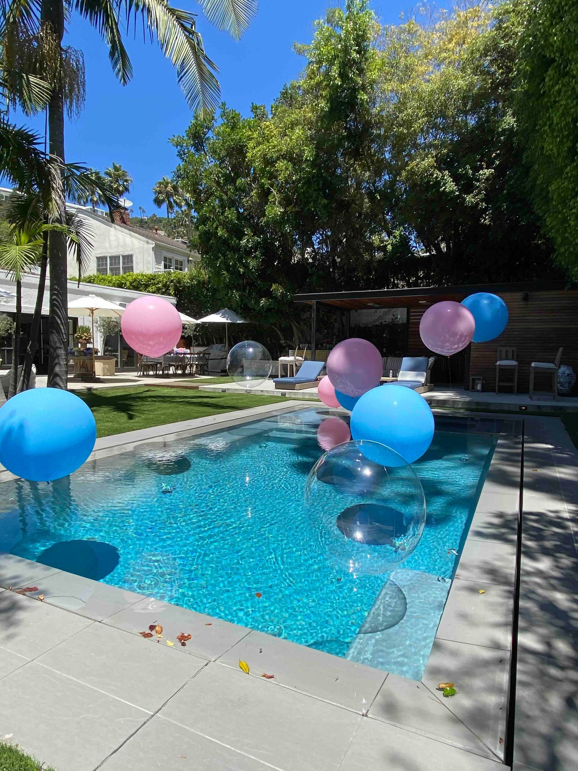 A swimming pool decorated with pink and blue balloons