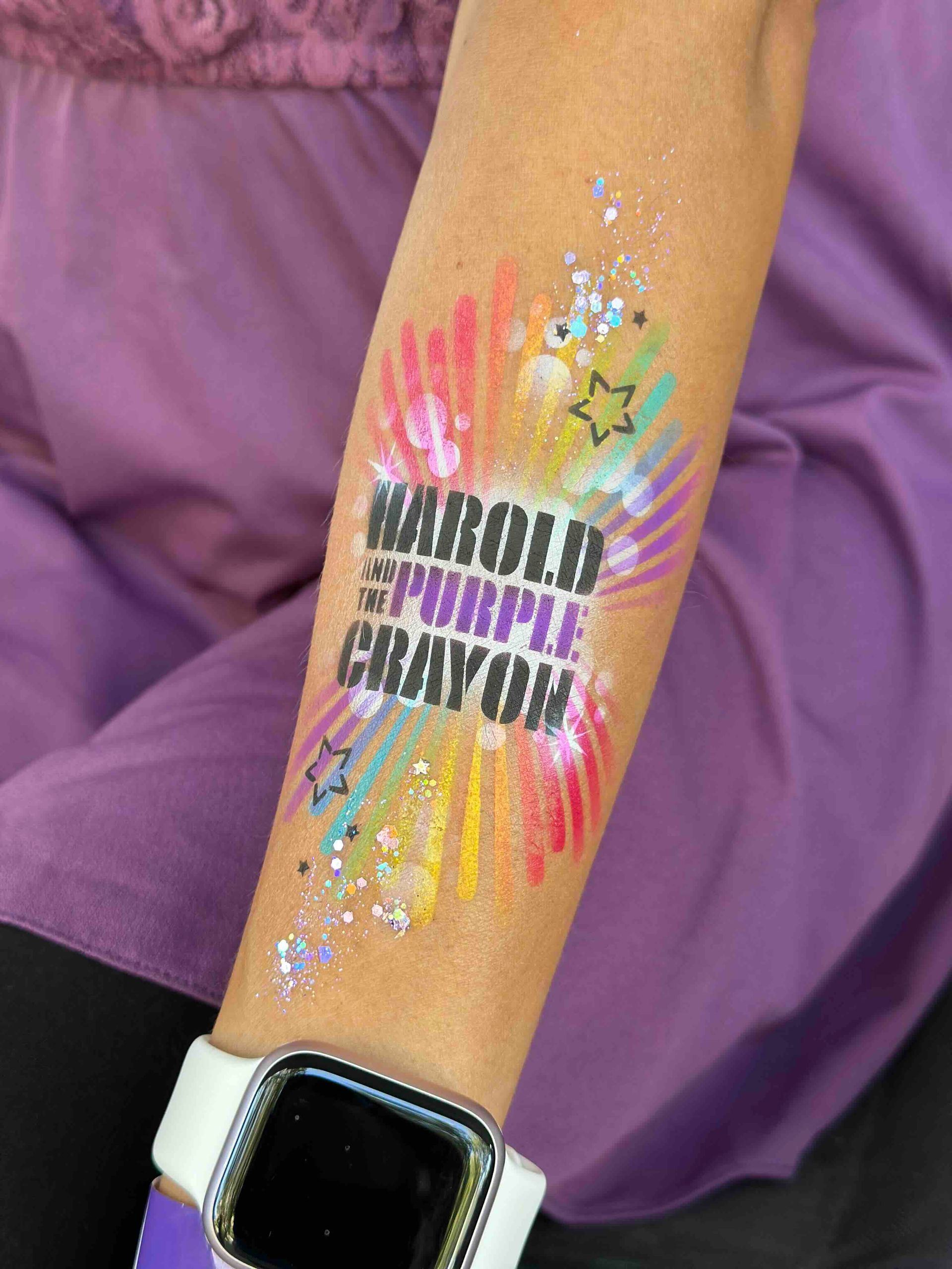 A person with a tattoo on their arm that says `` marold purple crayon ''.