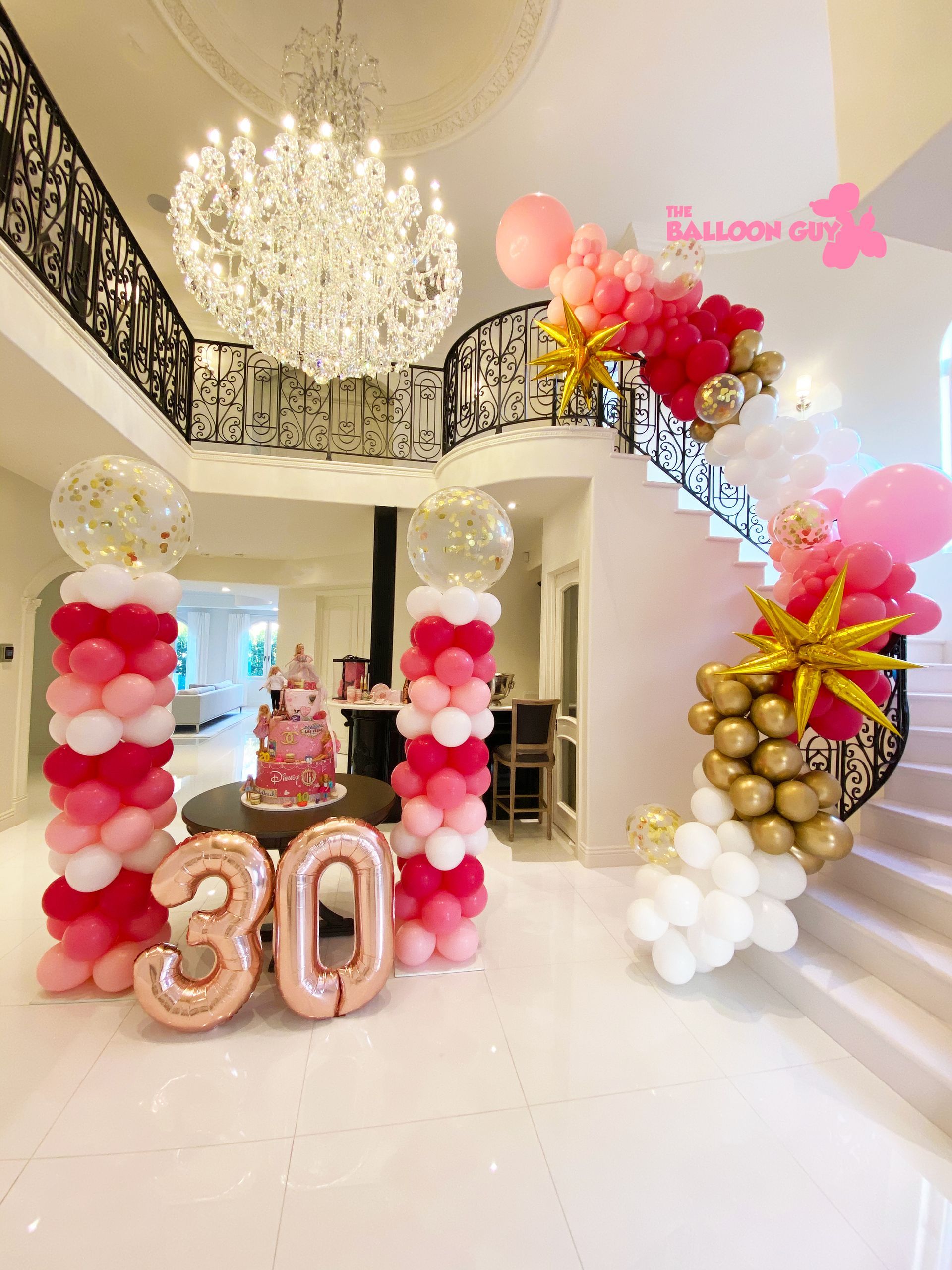 A room filled with balloons and a cake for a 30th birthday.