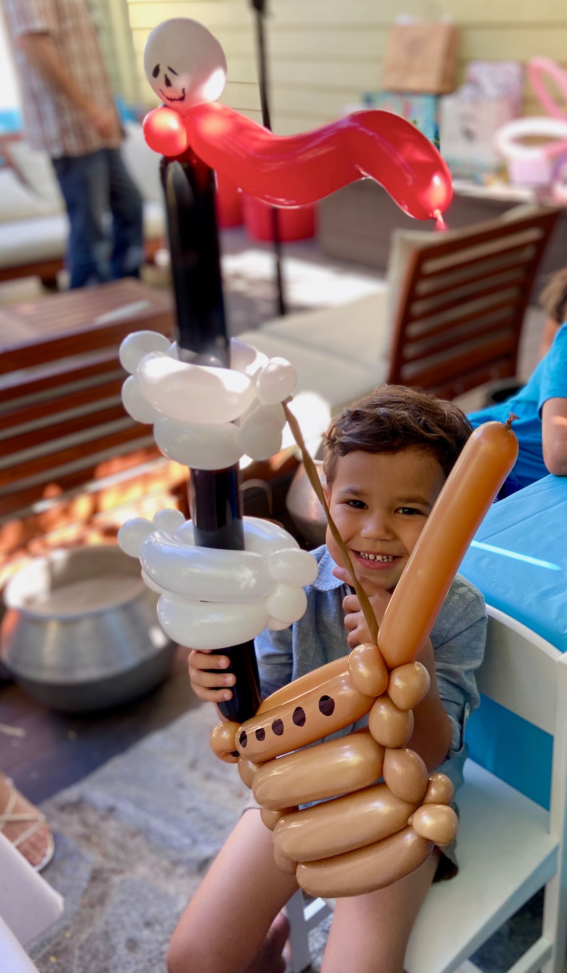 A young boy is holding a balloon that looks like a boat