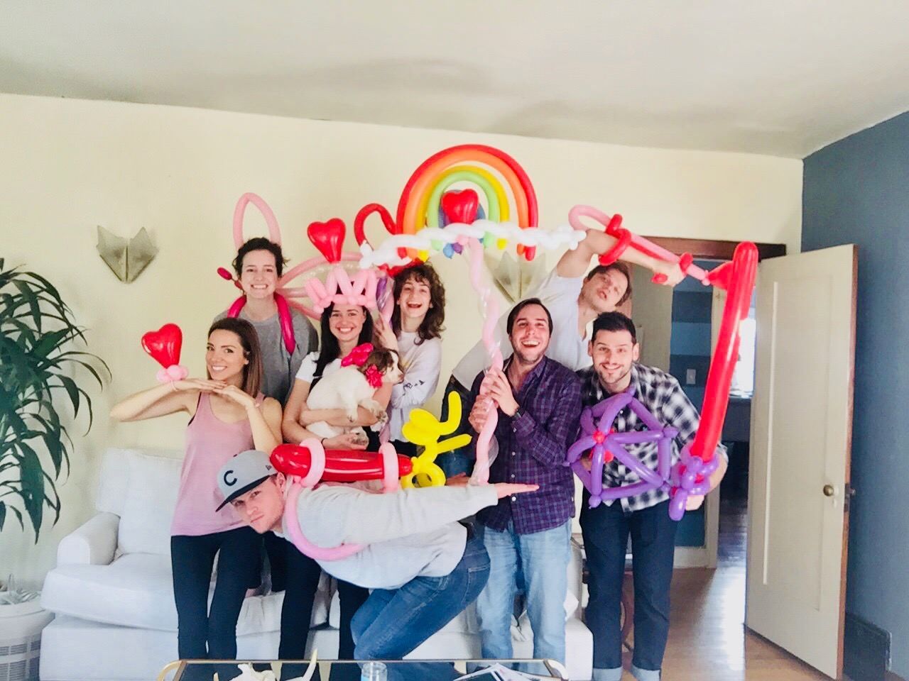 A group of people are posing for a picture with balloons in their hands