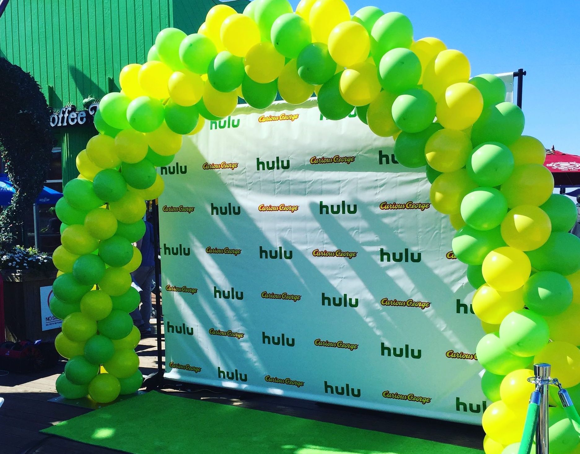 A green and yellow balloon arch with the word hulu on it
