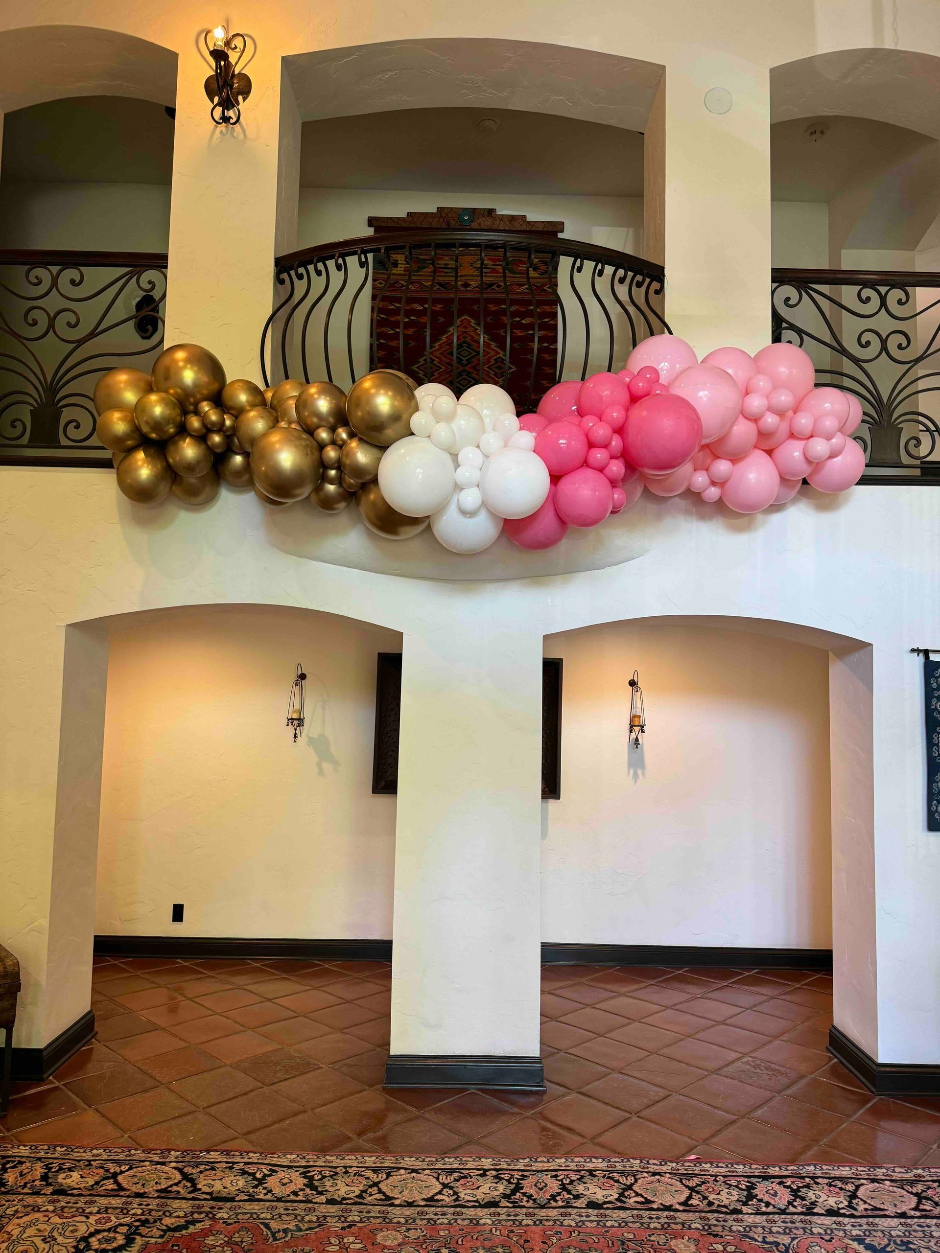 A bunch of balloons are hanging from the ceiling of a room.