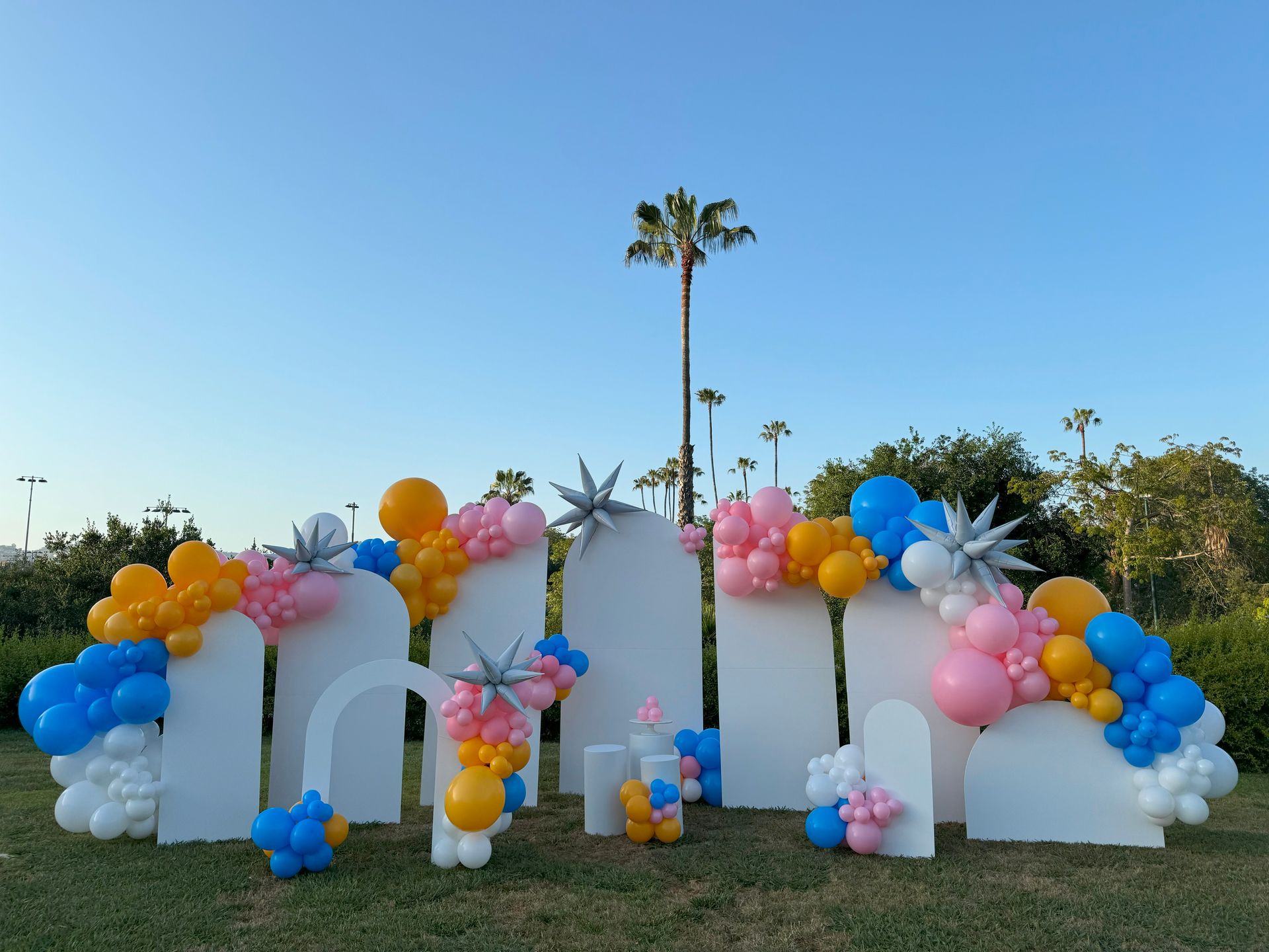 A bunch of balloons are sitting on top of a lush green field.