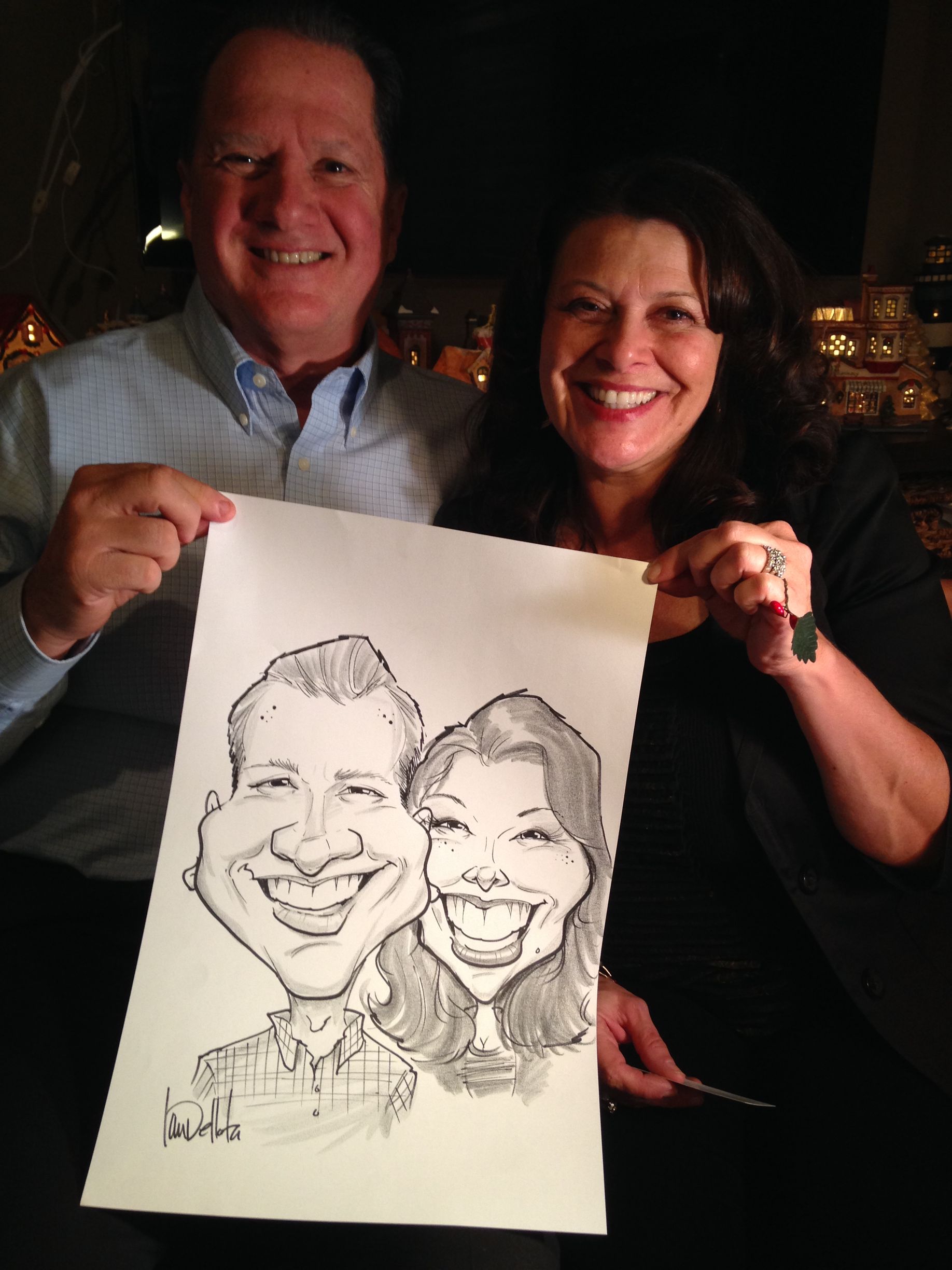 A man and a woman are holding a caricature of themselves