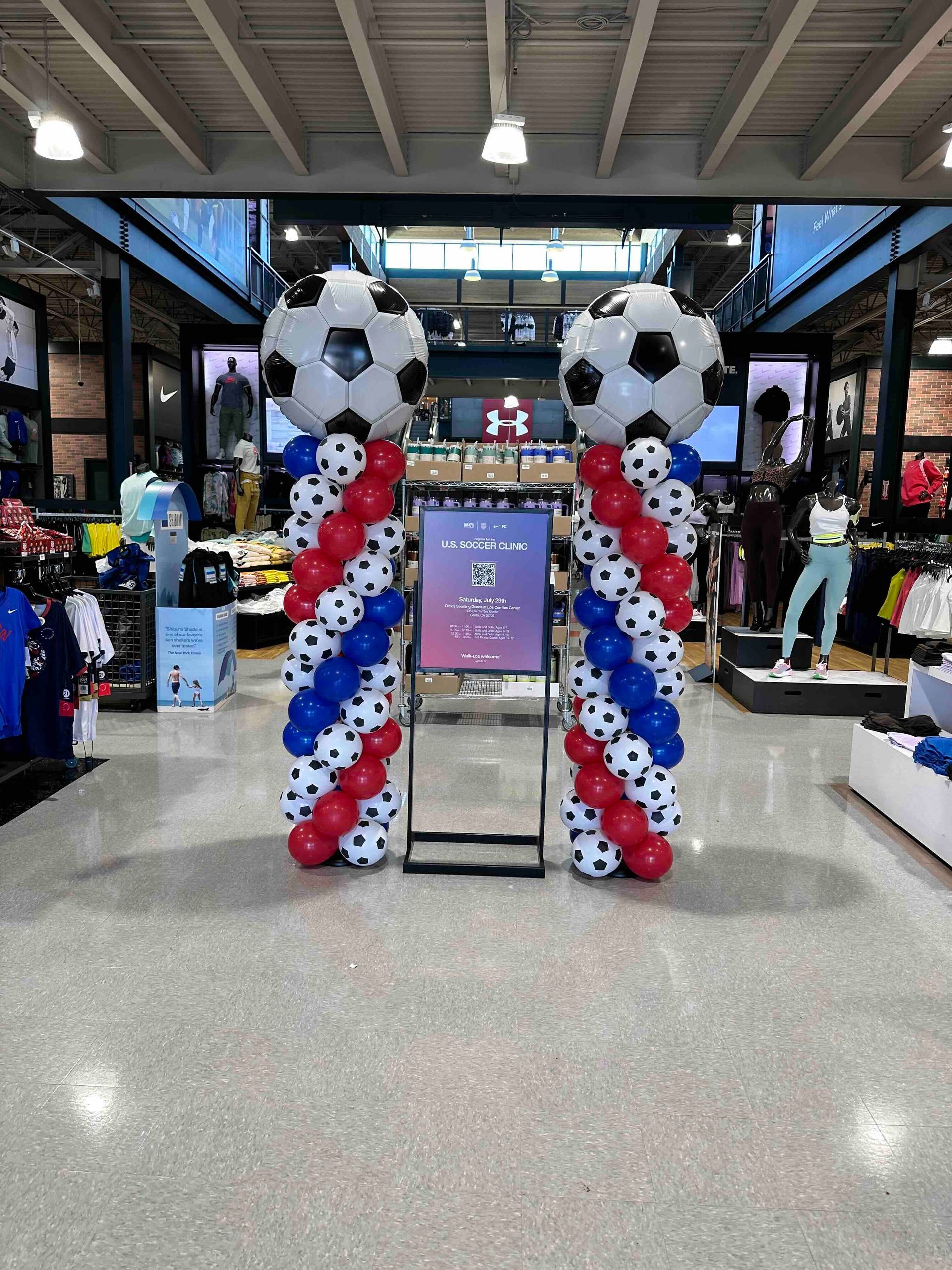A store is decorated with balloons in the shape of soccer balls.