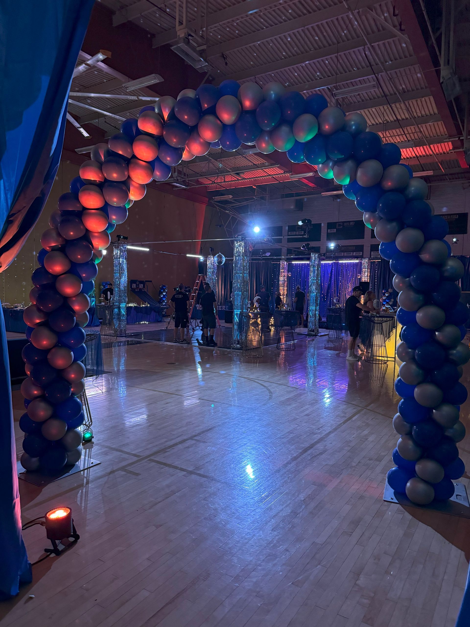 There is a large arch made of balloons in the middle of a room.