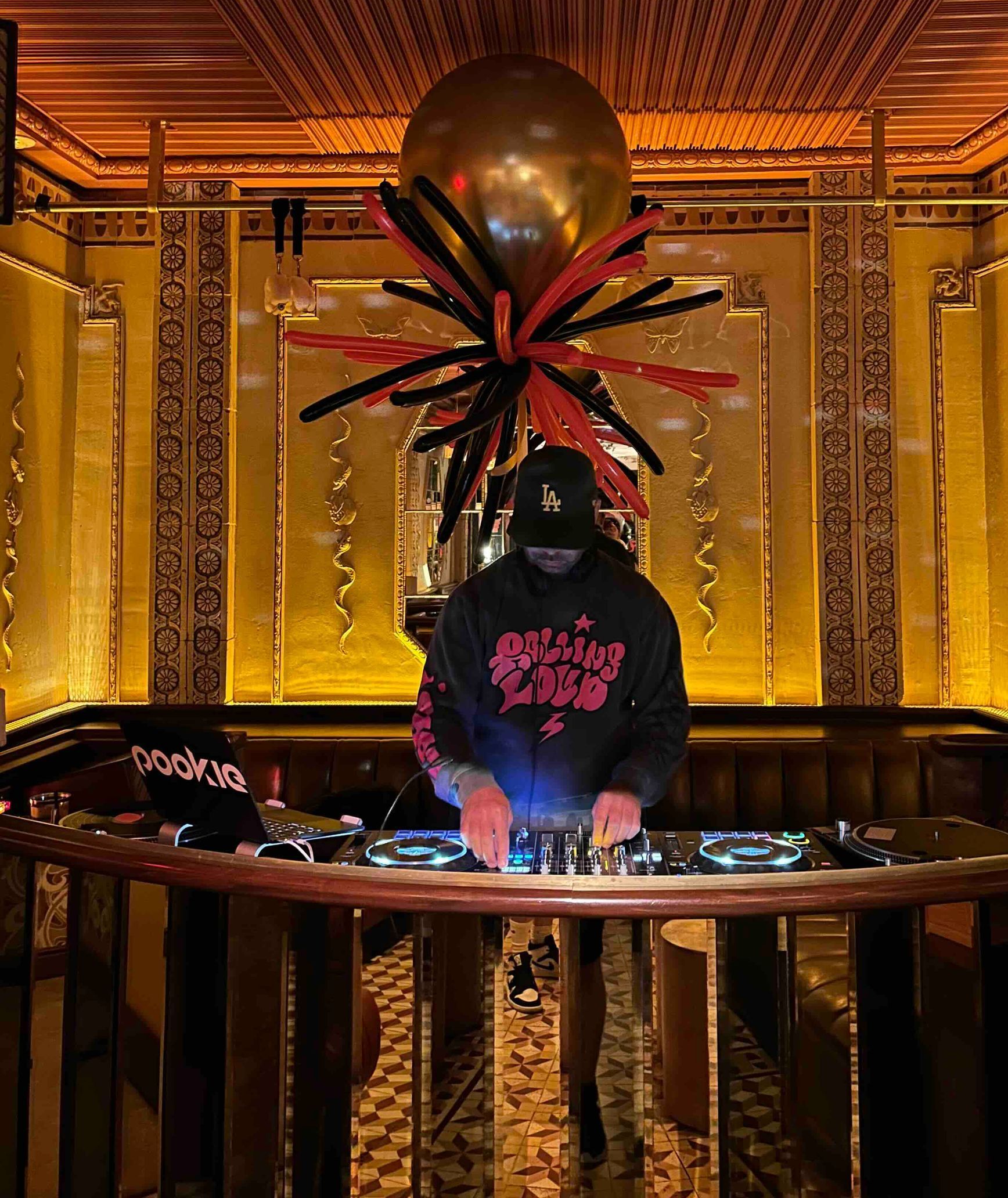 A DJ with balloons at a bar in Los Angeles.