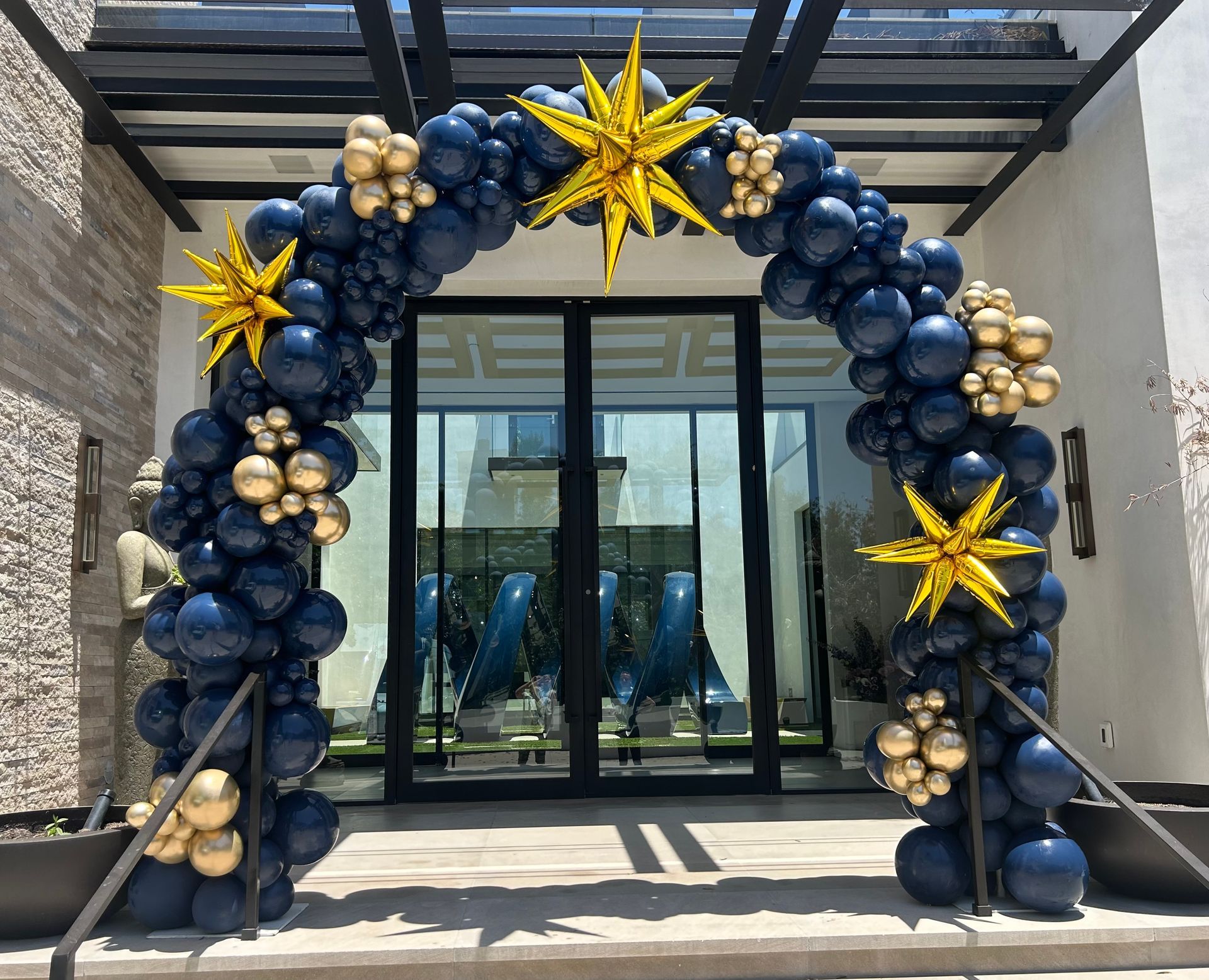 A large arch made of blue and gold balloons and stars