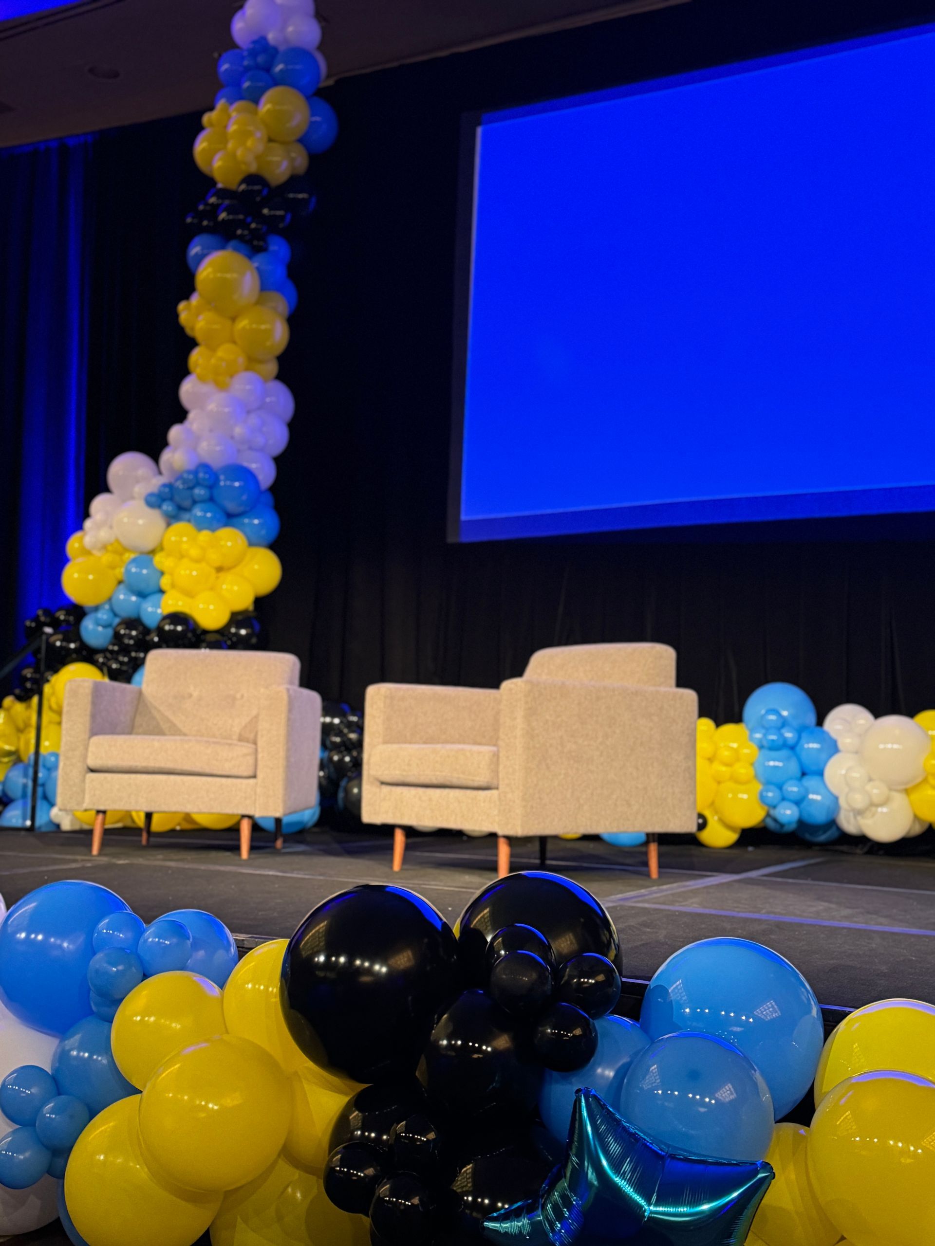A stage with chairs and balloons on it