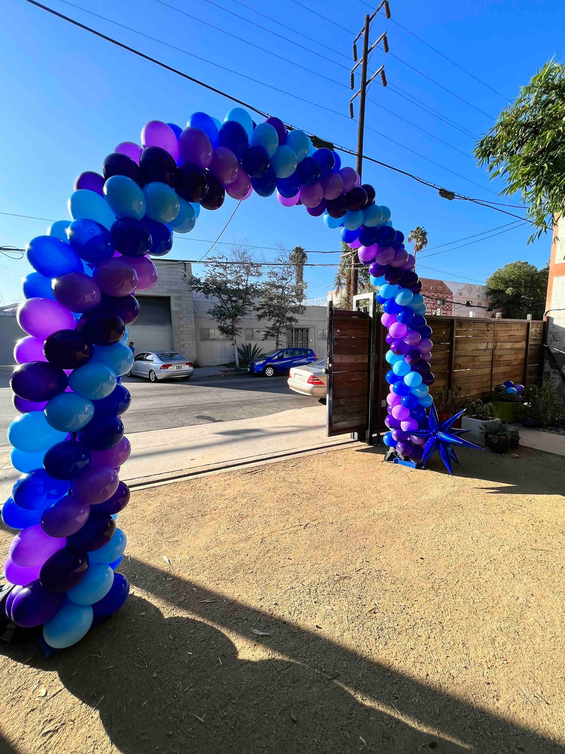 A large arch made of blue and purple balloons