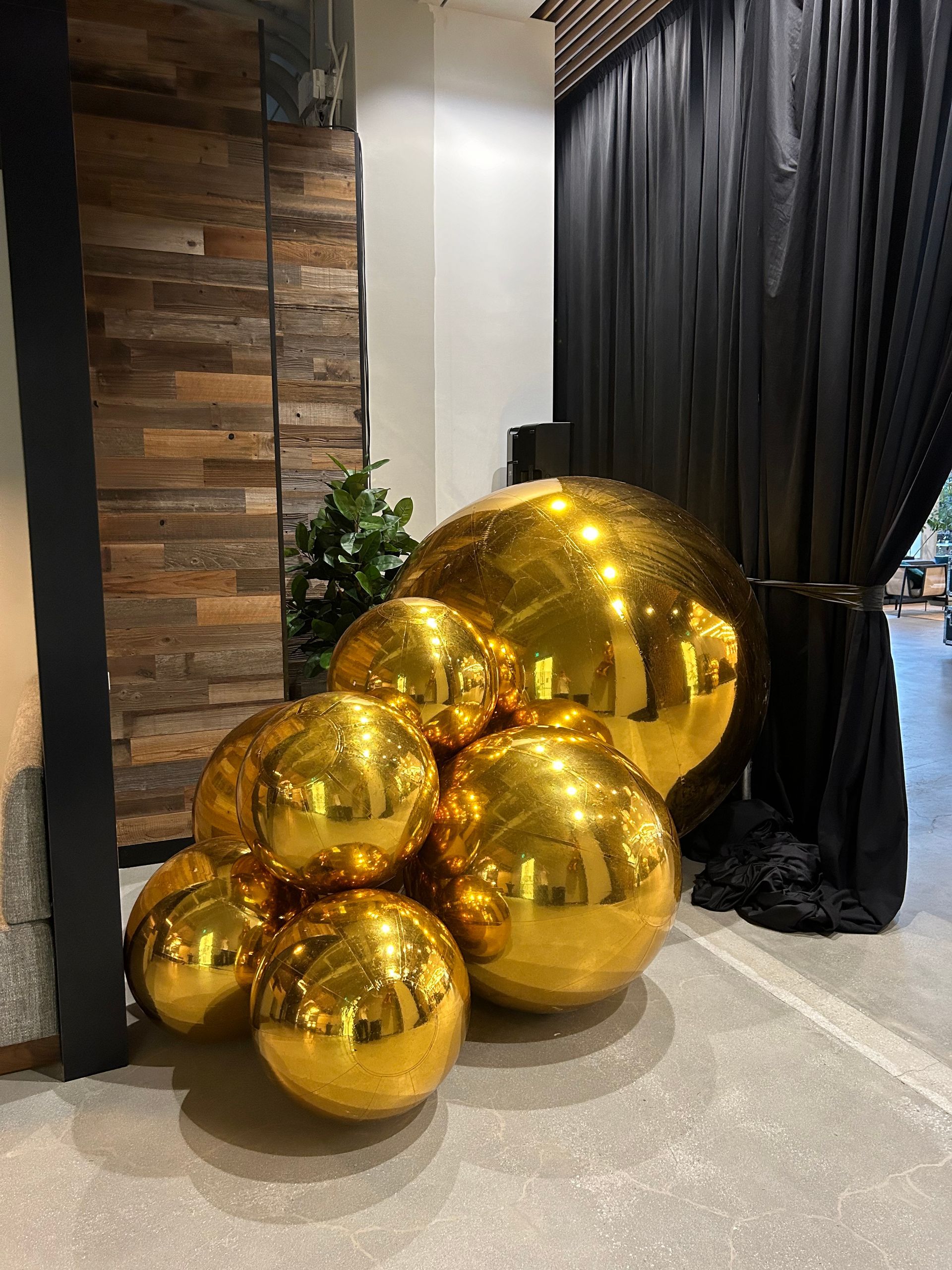 A bunch of gold balloons are sitting on the floor in a room.