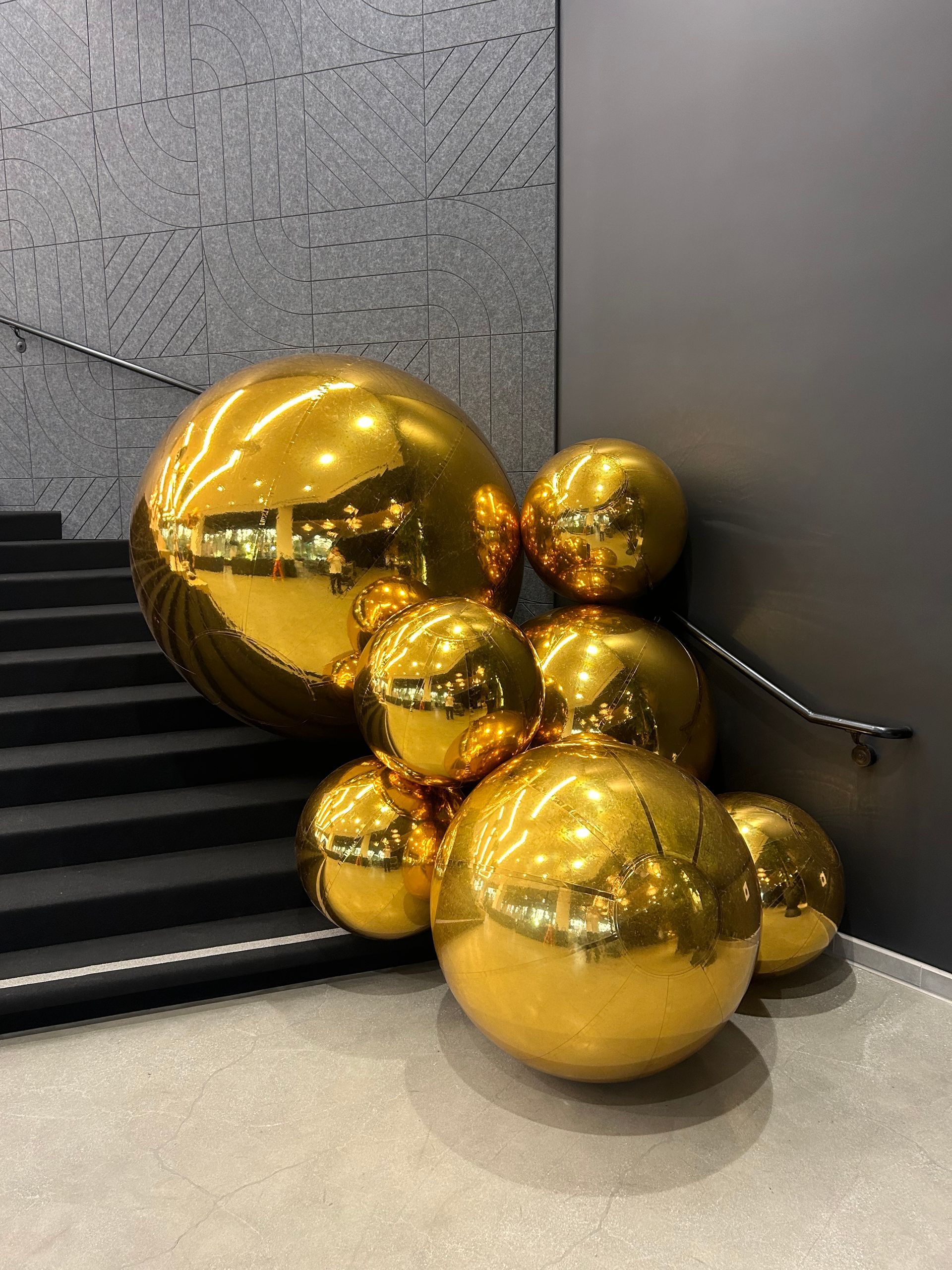 A bunch of gold balls are sitting next to a set of stairs.
