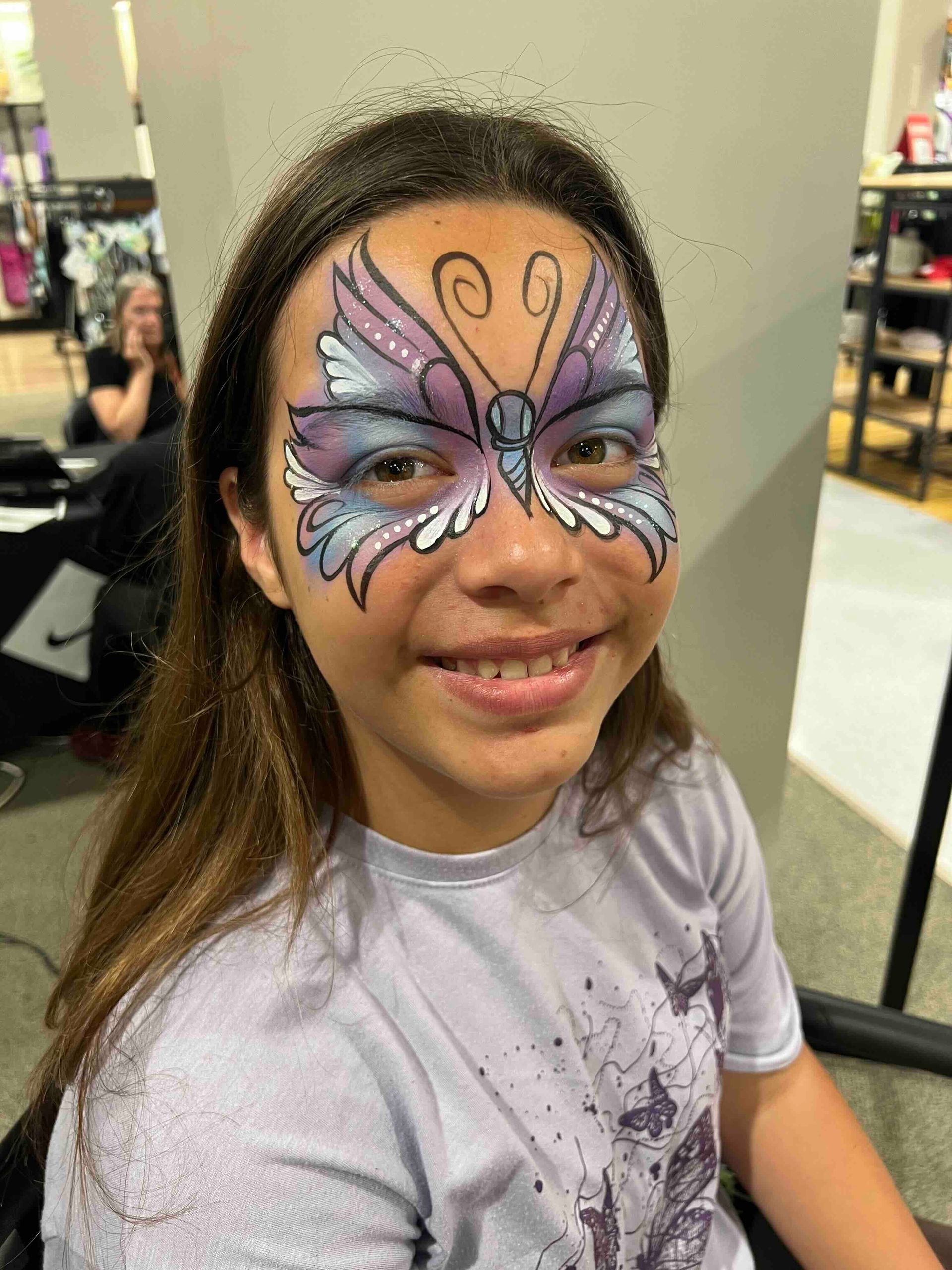 A young girl with a butterfly painted on her face.