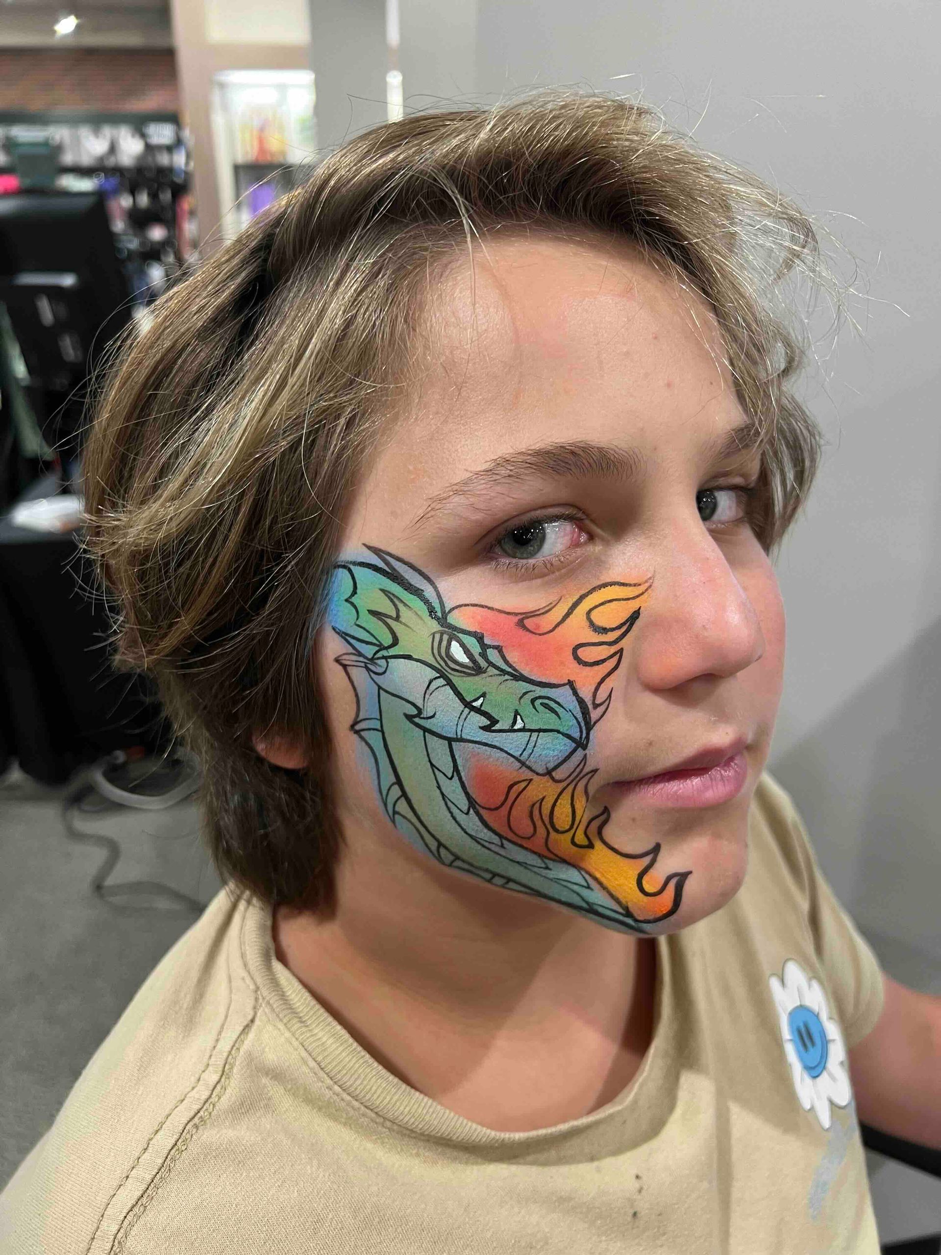 A young boy has a dragon painted on his face