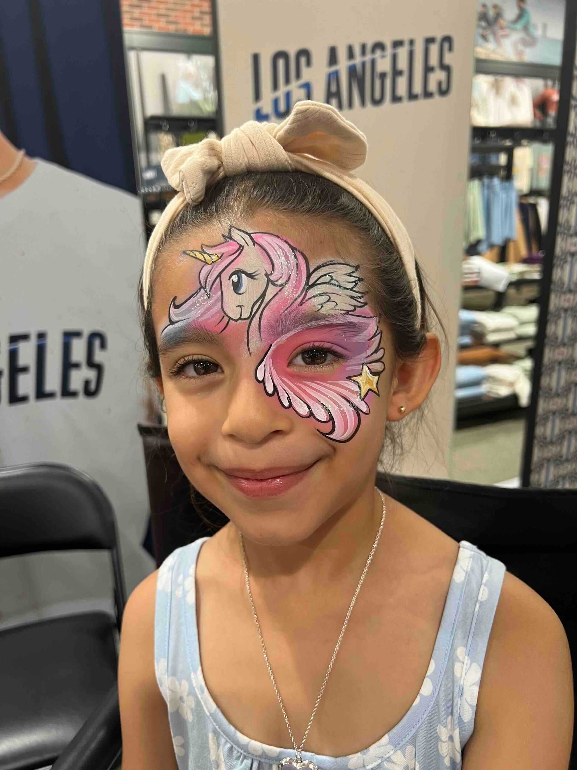 A little girl with a unicorn painted on her face