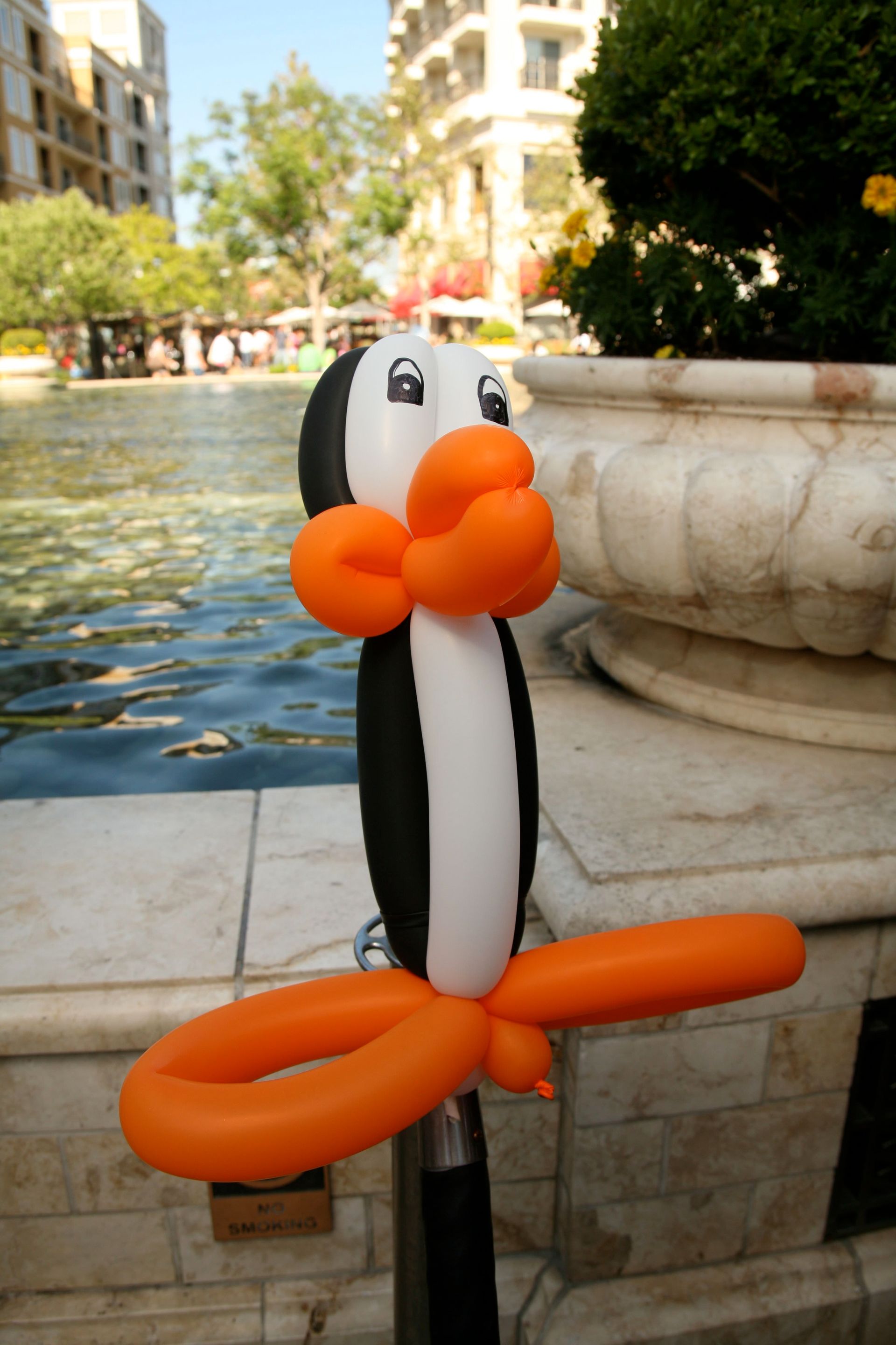 A penguin made out of orange and white balloons